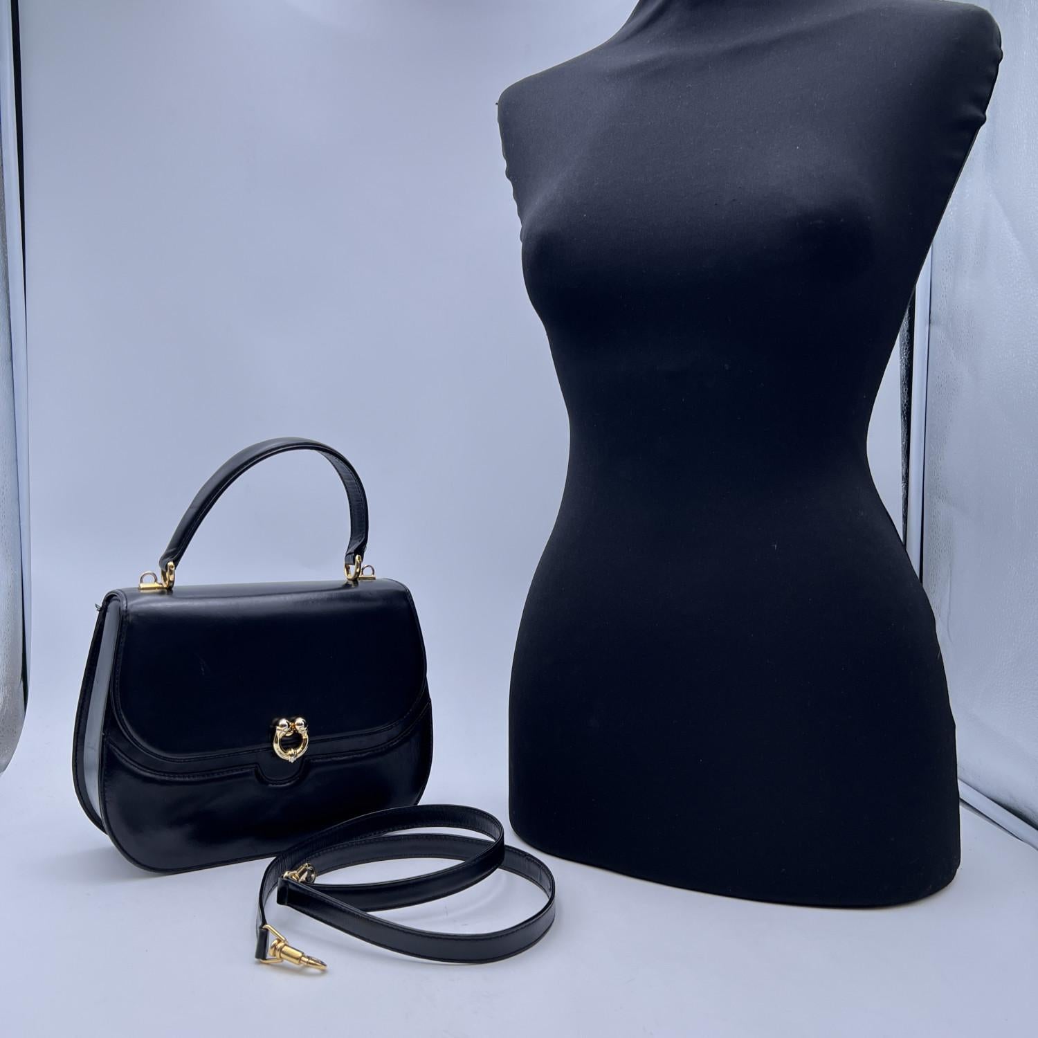 Gucci vintage handbag. Black leather. Flap with clasp closure. Gold metal shardware. Red leather lining. 2main sections and 1 side zip pocket and 1 side open pocket inside. Removable shoulder strap. 'Gucci - Made in Italy' embossed inside (with