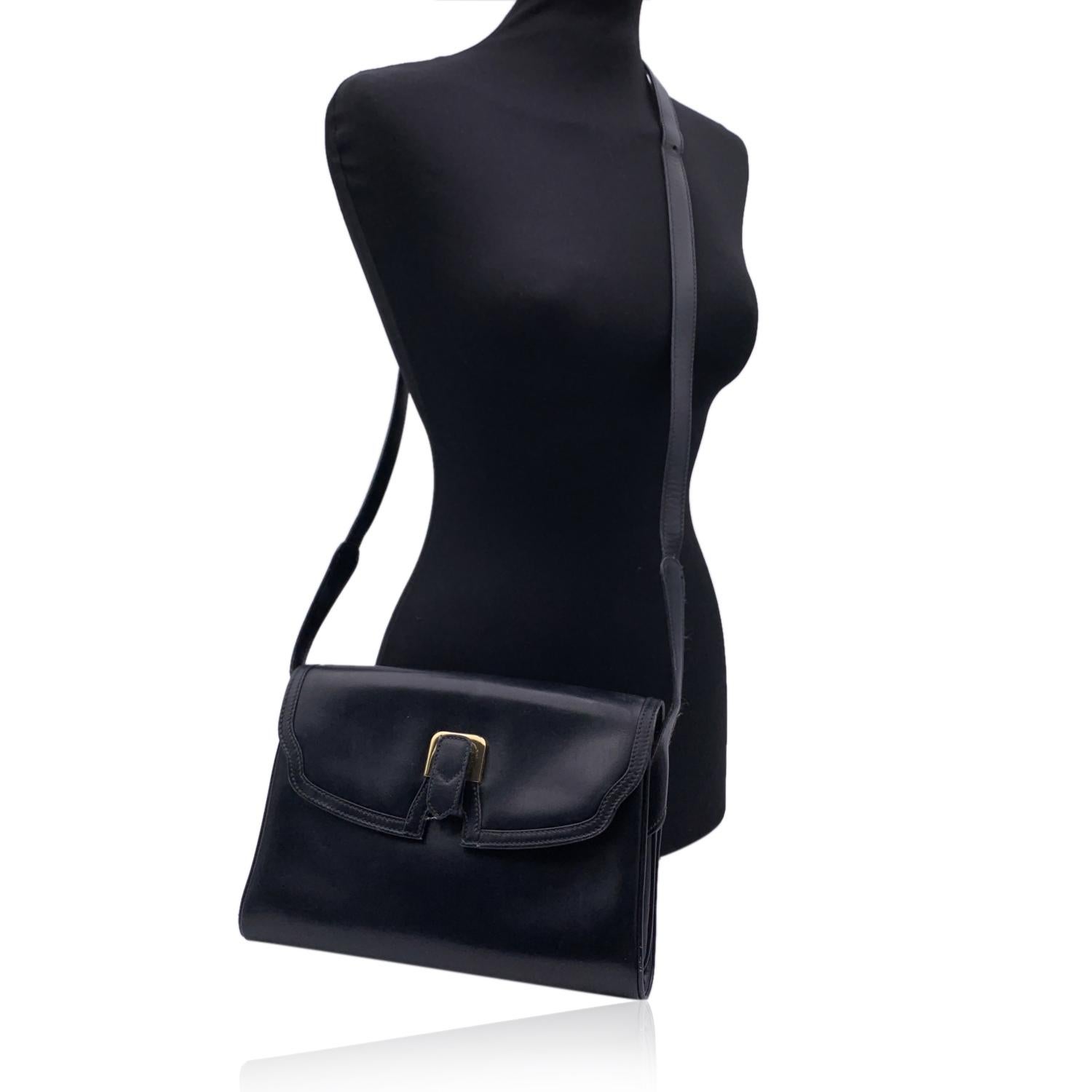 Vintage Gucci shoulder bag crafted in black leather .Flap with button closure. Gold metal hardware. Black leather lining . 3 open compartments inside. 1 open pocket under the flap. 1 side zip pocket inside. Adjustable shoulder strap. 'Made in Italy