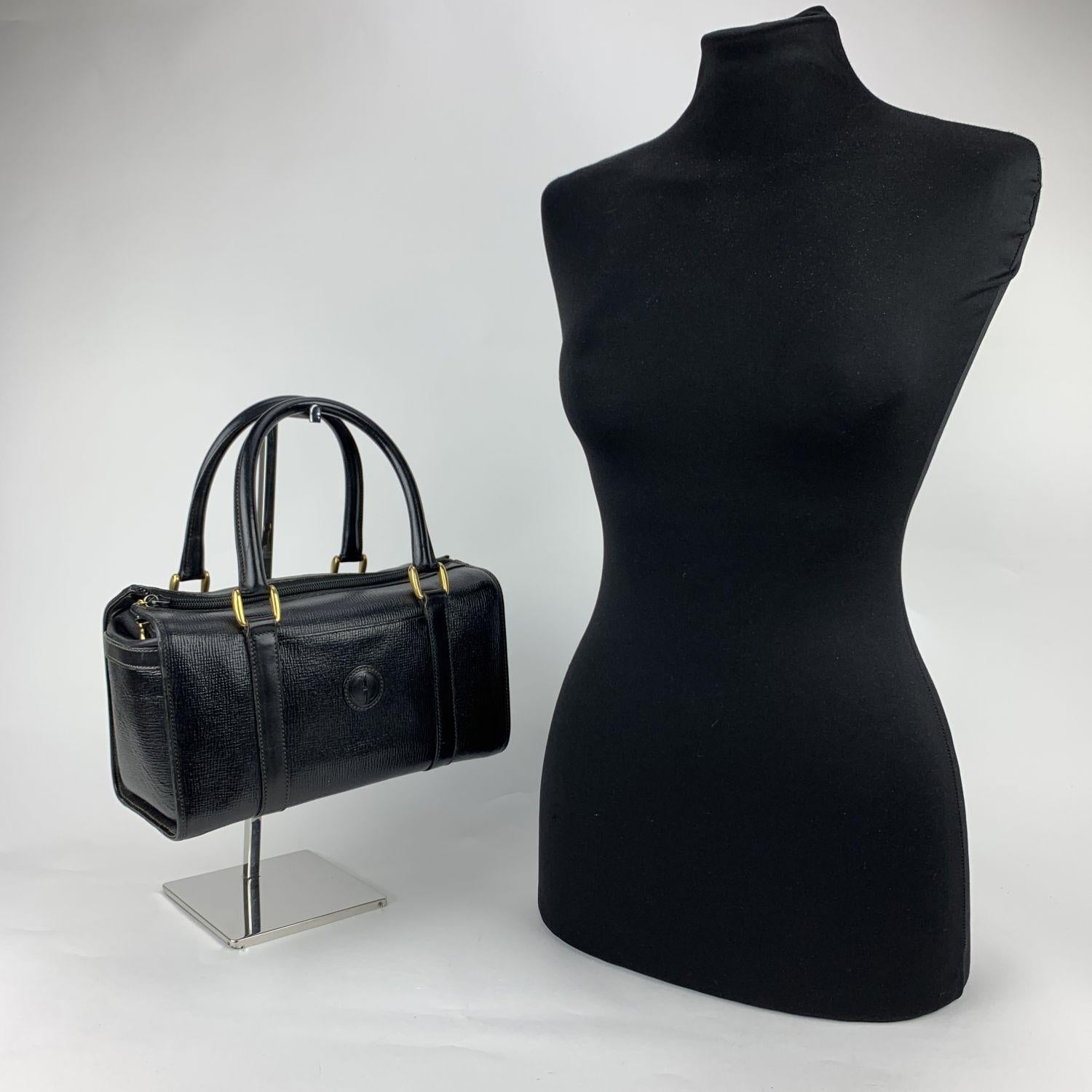 Vintage GUCCI black leather top handles bauletto bag Rolled black leather top handles. Upper zipper closure. Black suede interior. 1 side open pocket inside. 'GUCCI - Made in Italy' tag inside (with serial number on its reverse)

Details

MATERIAL: