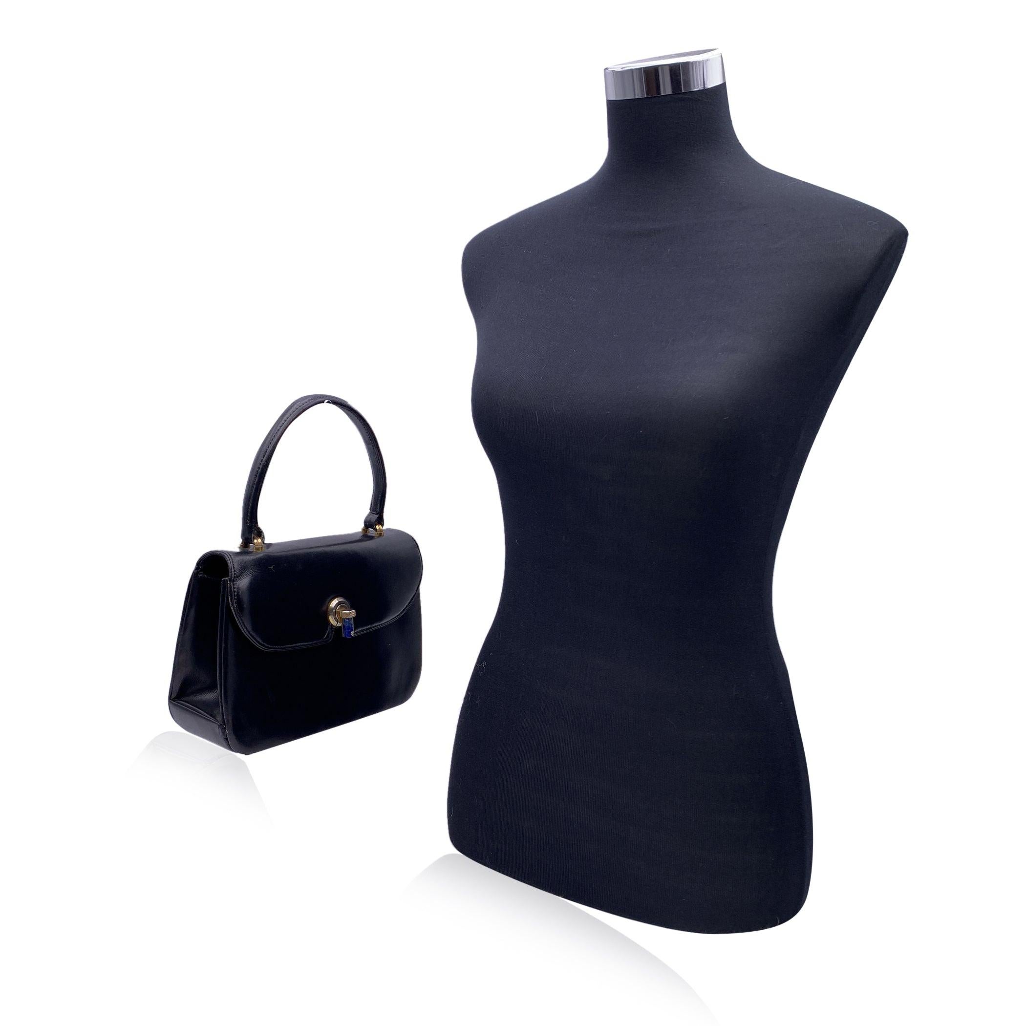 Beautiful Vintage rare Gucci handbag made in black leather. Gold metal and lapis flap closure. Top carry handles. 1 open pocket under the flap. Black leather interior. 3 open pockets inside and 1 pocket with kiss lock closure. 'Made in Italy by