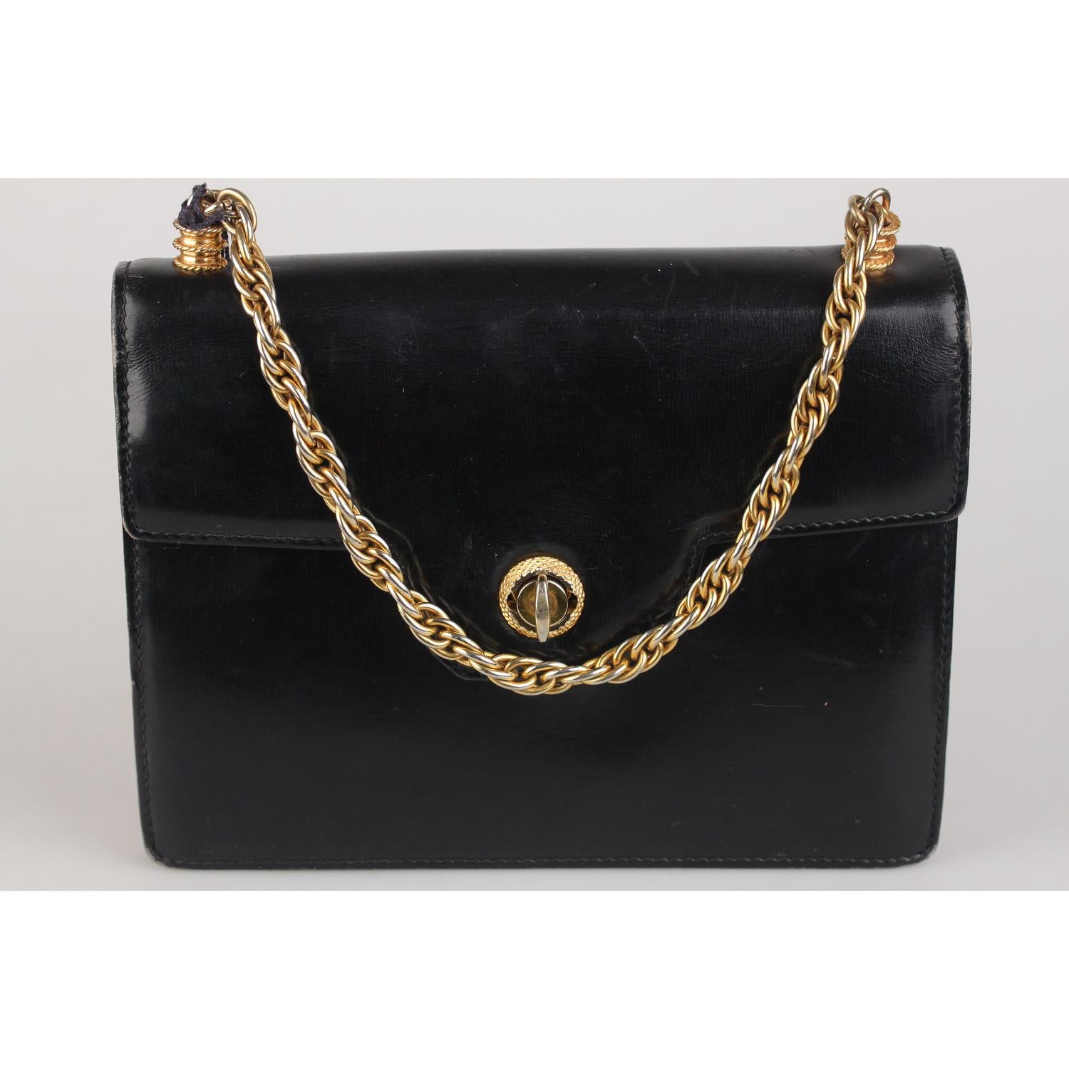Vintage GUCCI handbag from the 1960s, crafted in black genuine leather and gold metal chain handle. Flap with twist closure. Leather interior with 3 sideopen pockets and 1 side zip pockets. 'Made in Italy by GUCCI' embossed