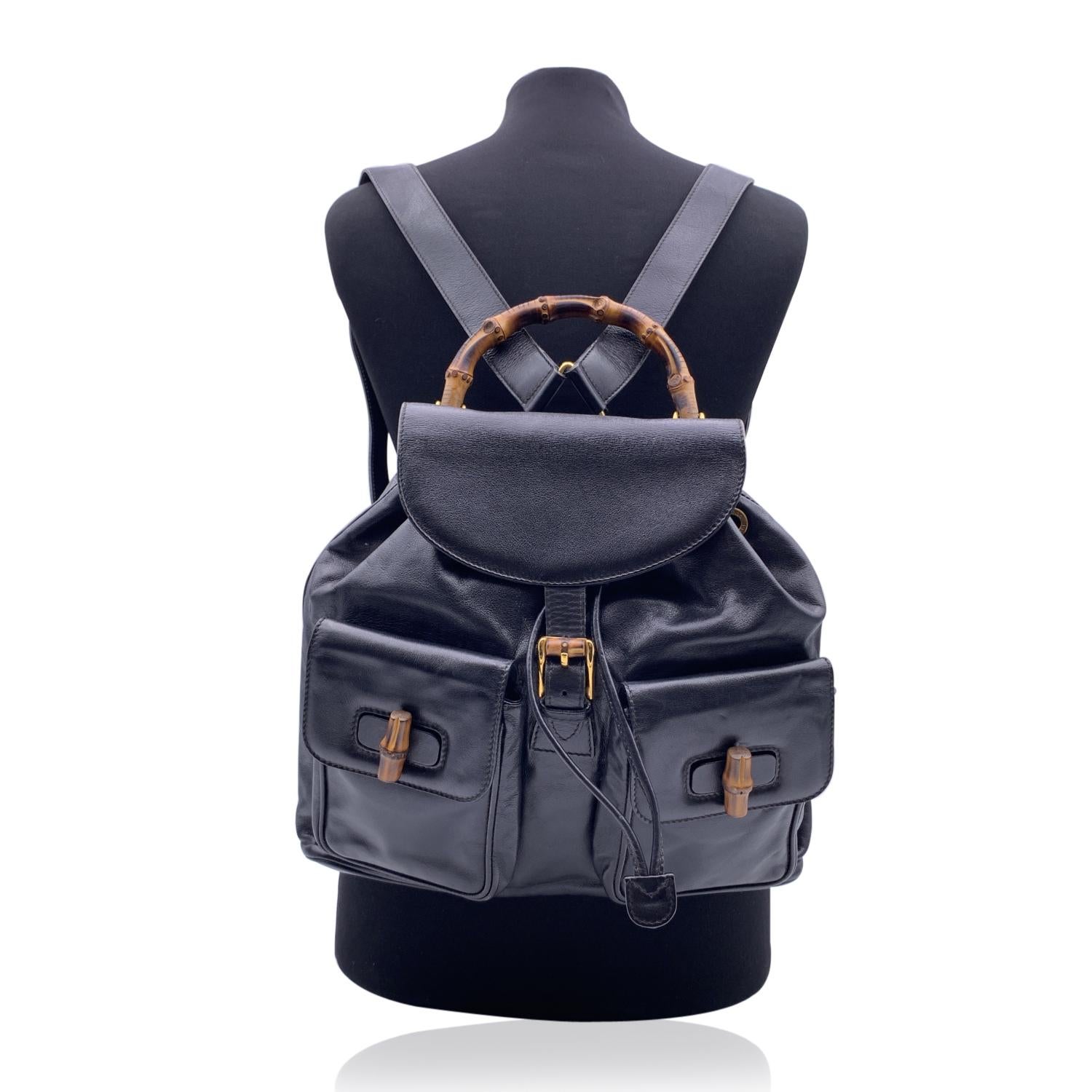 Vintage backpack by Gucci, crafted in black leather. It features Bamboo handle and and knobs. Flap with buckle closure and drawstring top opening. Internal black diamond lining. 1 side zipper pocket inside. Adjustable backstraps. 'GUCCI - Made in