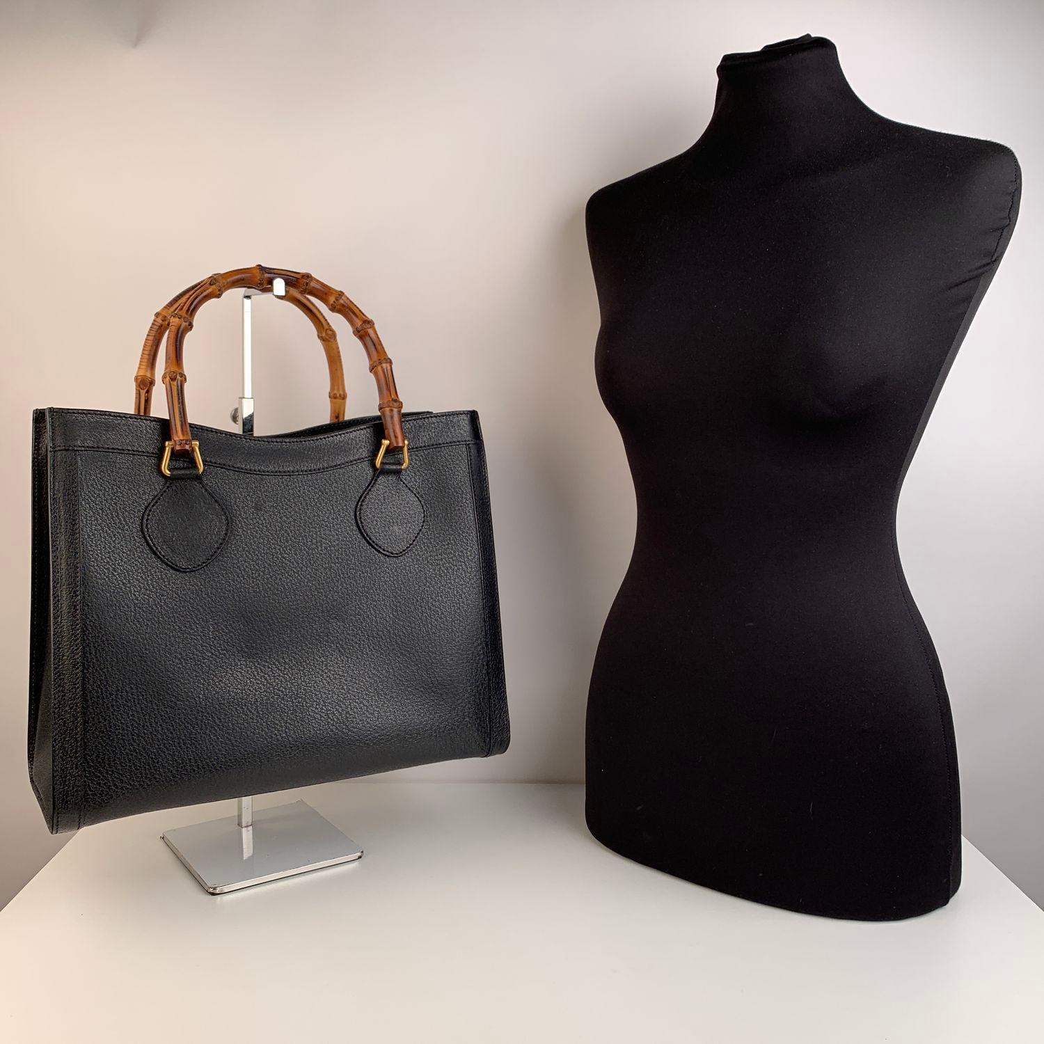 Beautiful Gucci Bamboo tote bag in black leather. Double distinctive Bamboo handle.  Princess Diana, was snapped carrying a this model on several occasions . Magnetic button closure on top. Black leather microfiber lining. 5 bottom feet. Gold metal