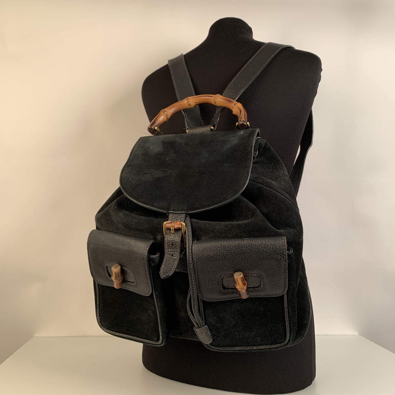 Vintage backpack by Gucci, crafted in black leather and suede. It features Bamboo handle and and knobs. Flap with buckle closure and drawstring top opening. Gold hardware. Internal Gucci diamond lining. 1 side zipper pocket inside (GUCCI - GG gold