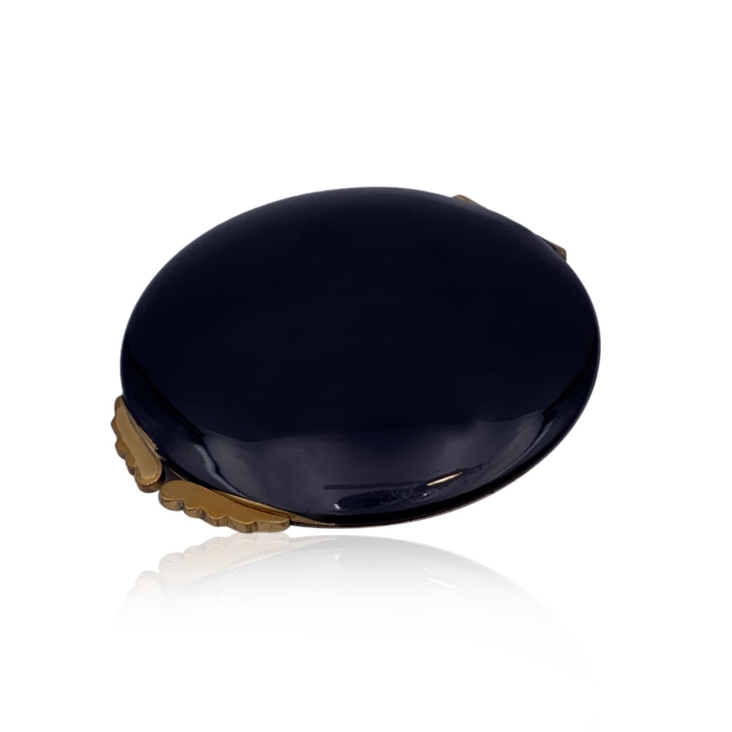 Rara polvera vintage Gucci redonda con espejo en color negro. detalles en metal dorado. La parte inferior de la polvera conserva la rejilla para polvos extraíble original, por lo que permite rellenar los polvos sueltos. Puede utilizarse para polvos