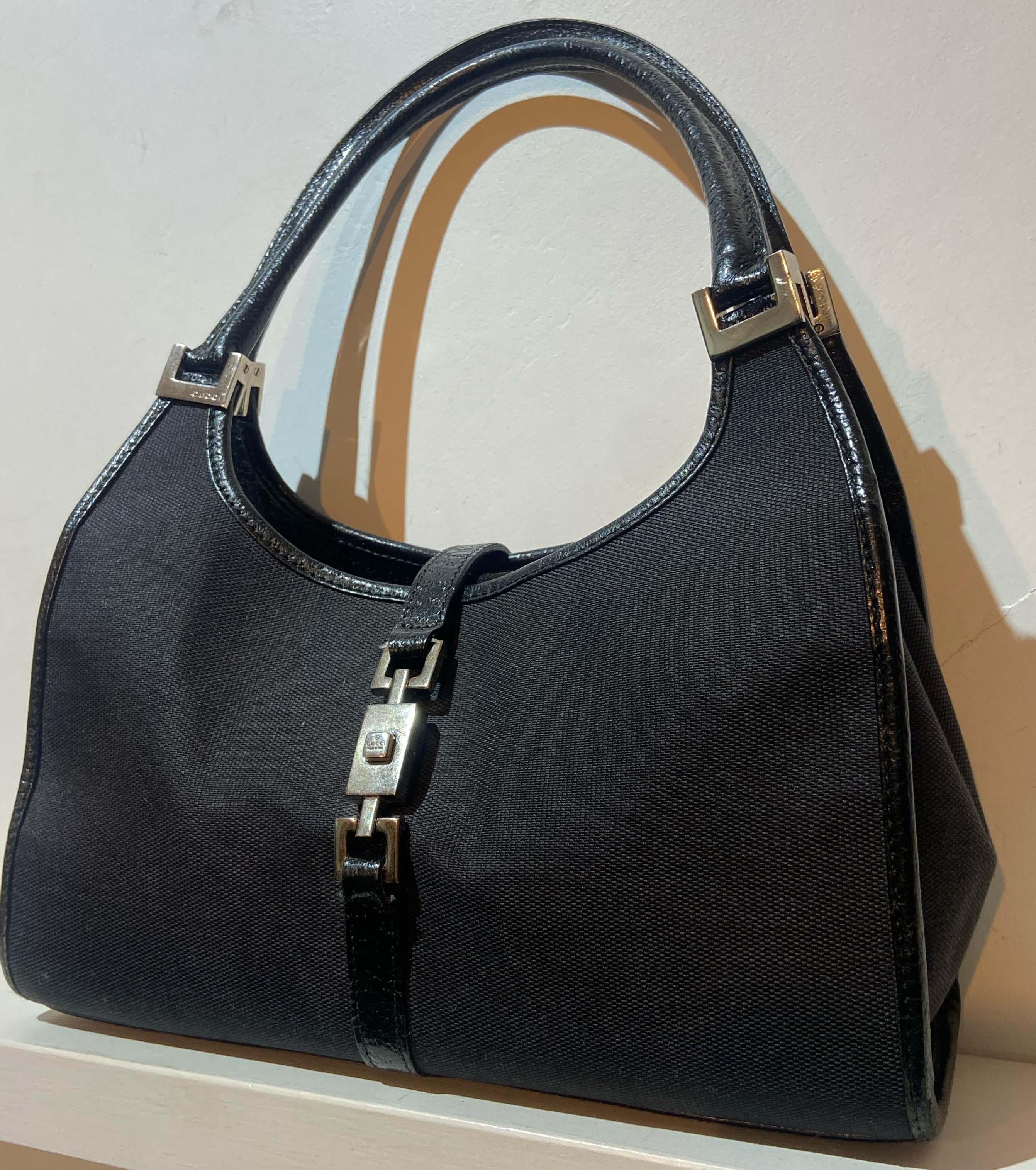 Vintage Gucci Jackie canvas black bag.
Feature leather trim, two top handles, fold over top internal zip pocket in the main compartment. Fastens with a silver tone front clip-lock . In excellente vintage condition.

Brand: Gucci
Color: Black
Fabric: