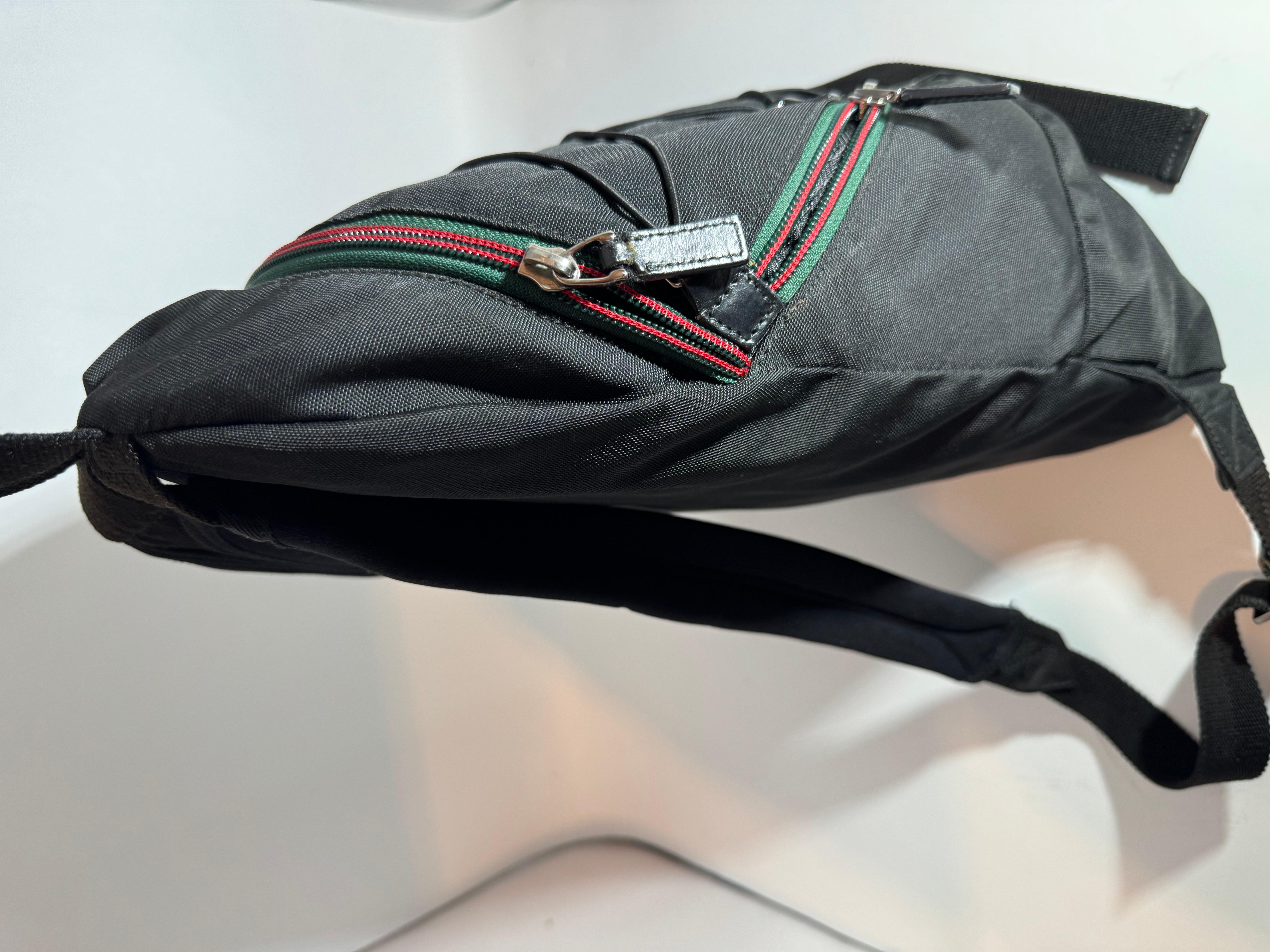This is an authentic Pre owned GUCCI Vintage Black Nylon , Small Eden Day Back Pack Black, Made in Italy.
This stylish backpack is crafted of Gucci Nylon The bag features two external pocket, nylon shoulder straps, and Red And Green Zipper with
