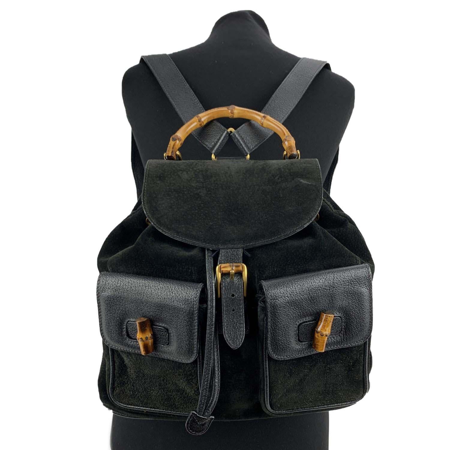 Vintage backpack by Gucci, crafted in black suede and leather. It features Bamboo handle and and knobs. Flap with buckle closure and drawstring top opening. Internal black diamond lining. 1 side zipper pocket inside (GUCCI - GG gold metal zipper