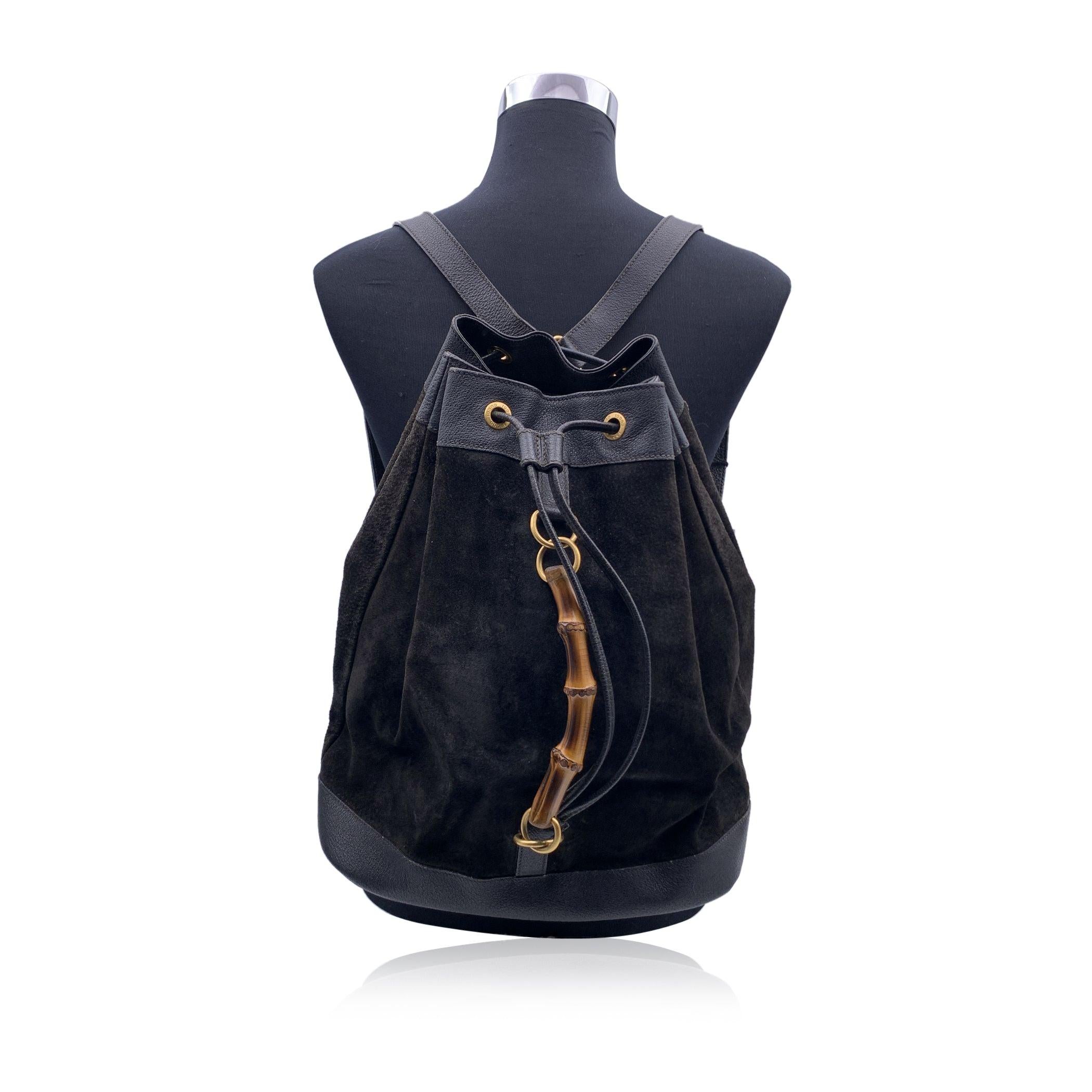Vintage backpack by Gucci, crafted in black suede and leather. It features a drawstring closure, a Bamboo handle and adjustable backstraps. Internal black diamond lining. 1 side zipper pocket inside (GUCCI - GG gold metal zipper pull). 'GUCCI - Made