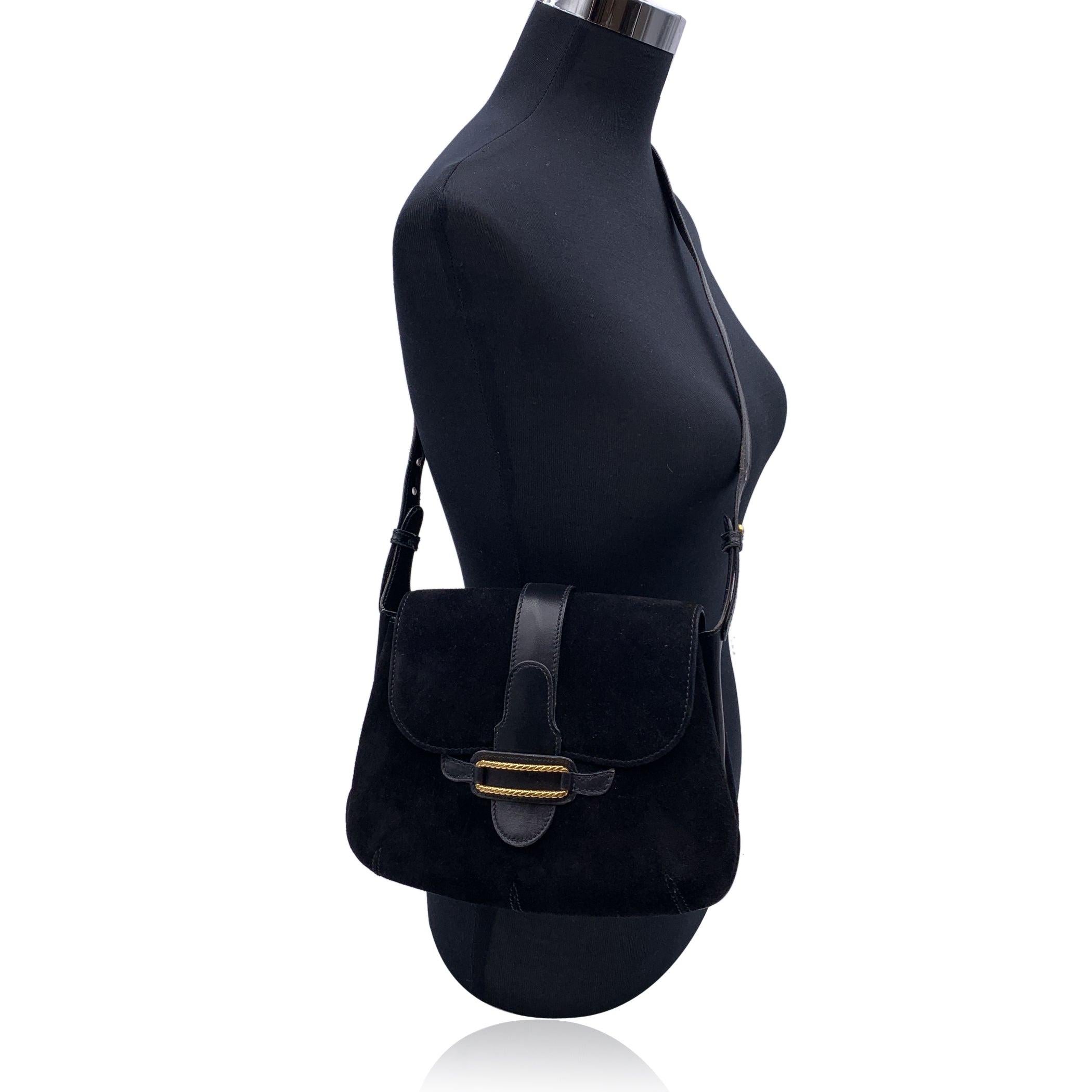 Vintage Gucci shoulder bag in black suede and leather. Flap closure with gold metal application on the front. Black leather lining. 1 side zip pocket and 2 side open pockets inside. Adjustable shoulder strap. 'Made in Italy by GUCCI' embossed inside