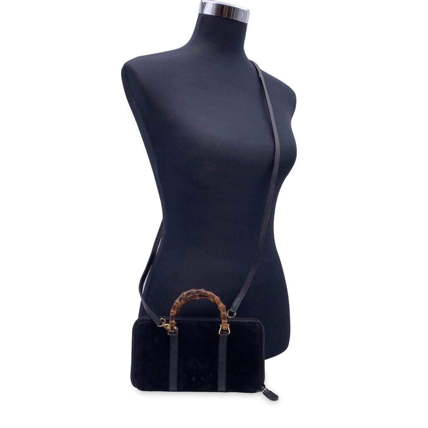 Beautiful Gucci black suede 'Bamboo' Wallet on Chain. The wallet features two bamboo handles and a removable shoulder strap. Black leather trim and shoulder strap. Upper zipper closure. Black leather interior. 2 bill compartments and 1 middle zip