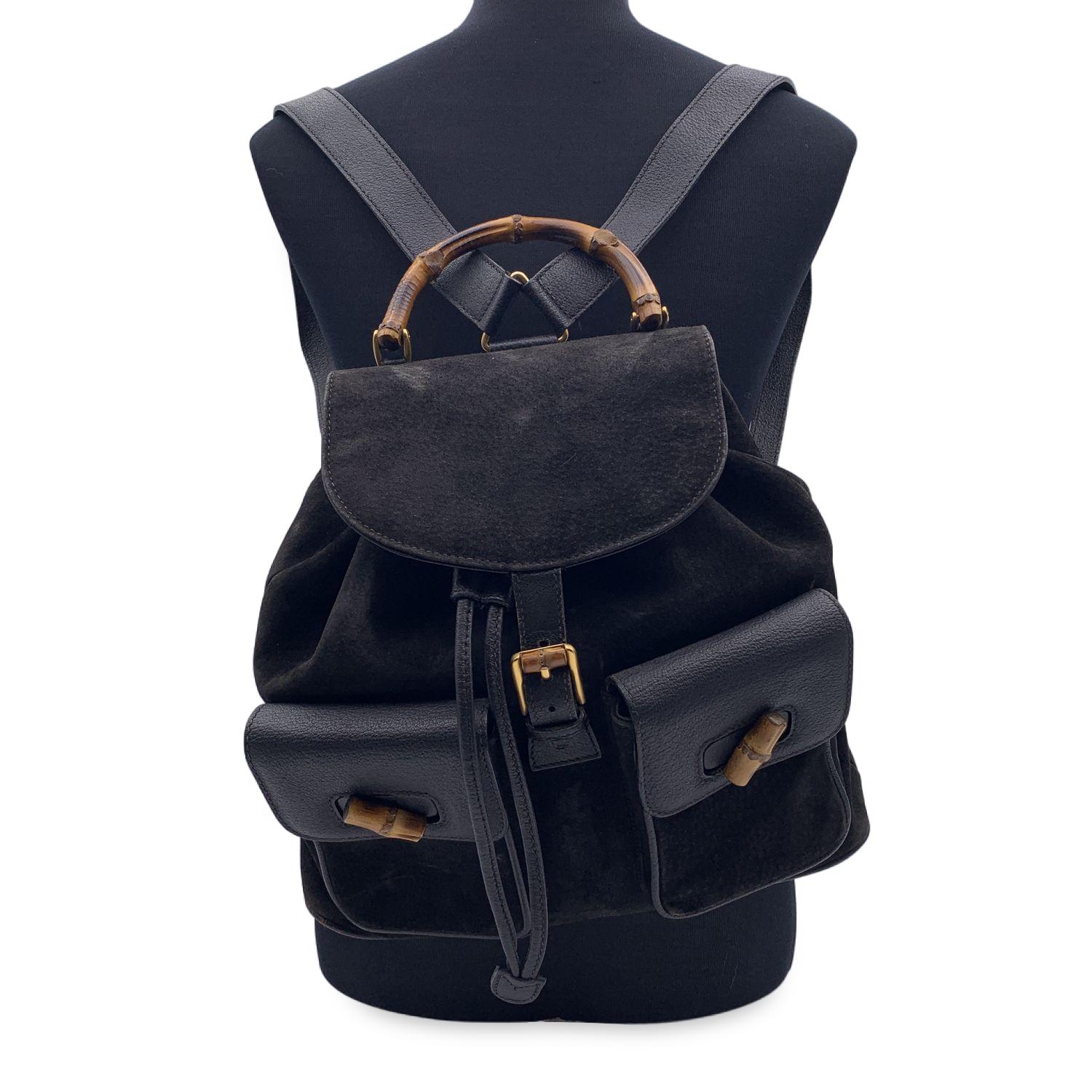 Vintage backpack by Gucci, crafted in black suede and leather. It features Bamboo handle and and knobs. Flap with buckle closure and drawstring top opening. Internal black diamond lining. 1 side zipper pocket inside. Adjustable backstraps. 'GUCCI -