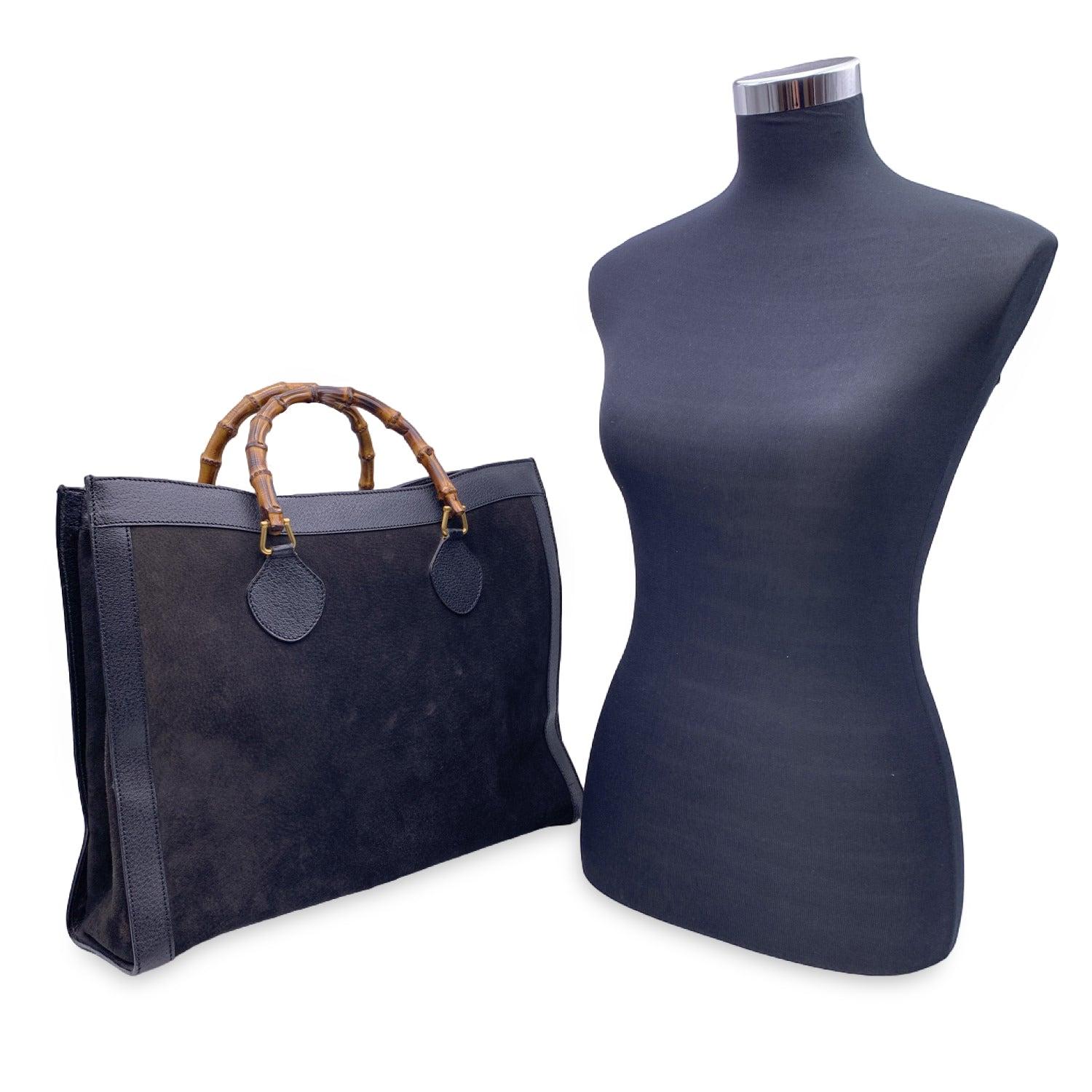 Beautiful Gucci Bamboo Maxi XL tote bag in black suede and leather. Double distinctive Bamboo handle. Princess Diana, was snapped carrying a this model on several occasions. Magnetic button closure on top. 5 bottom feet. Gold metal hardware. 2 main