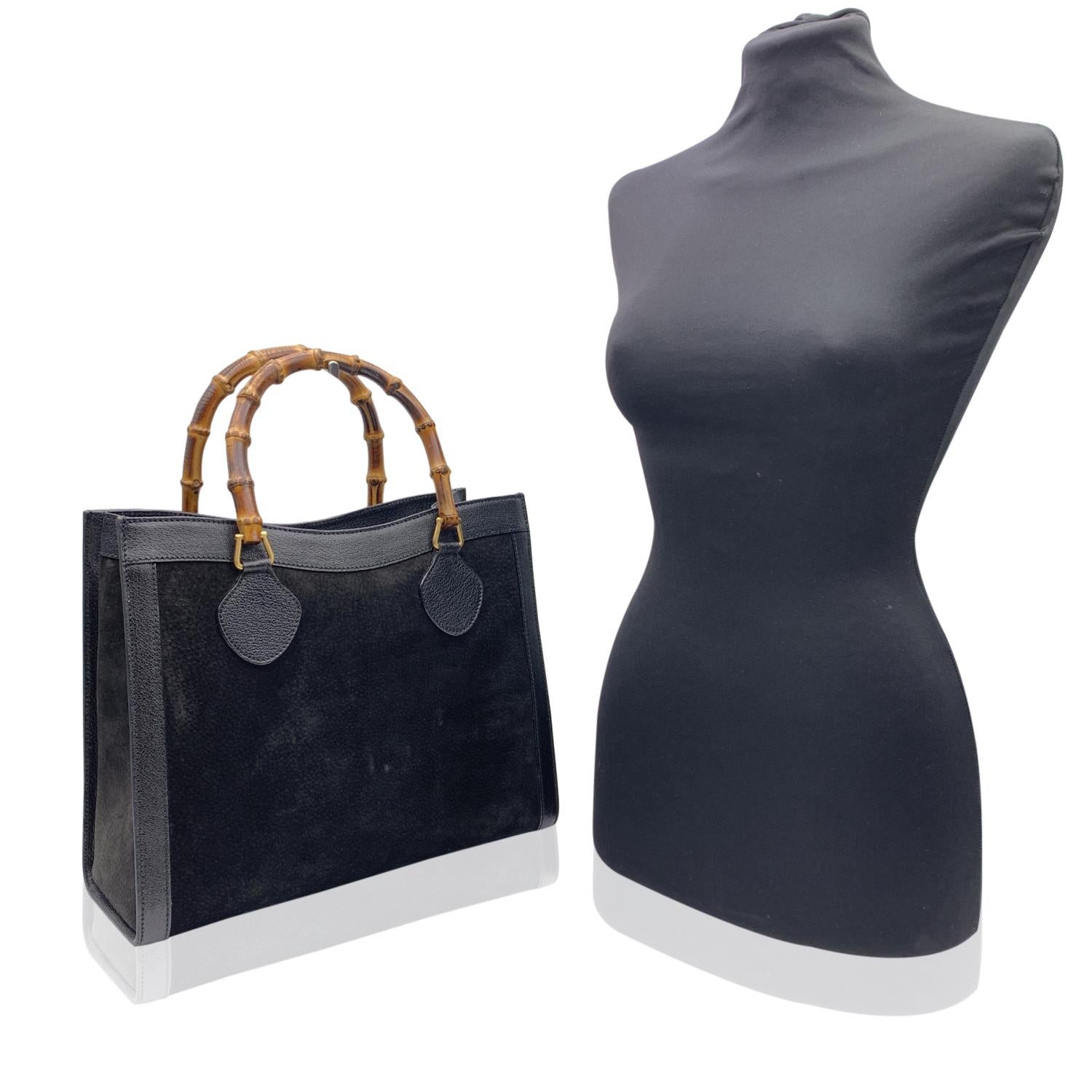 Beautiful Gucci Bamboo tote bag in black suede with genuine leather trim. Double distinctive Bamboo handle. Princess Diana, was snapped carrying a this model on several occasions. Magnetic button closure on top. 5 bottom feet. Gold metal hardware. 1