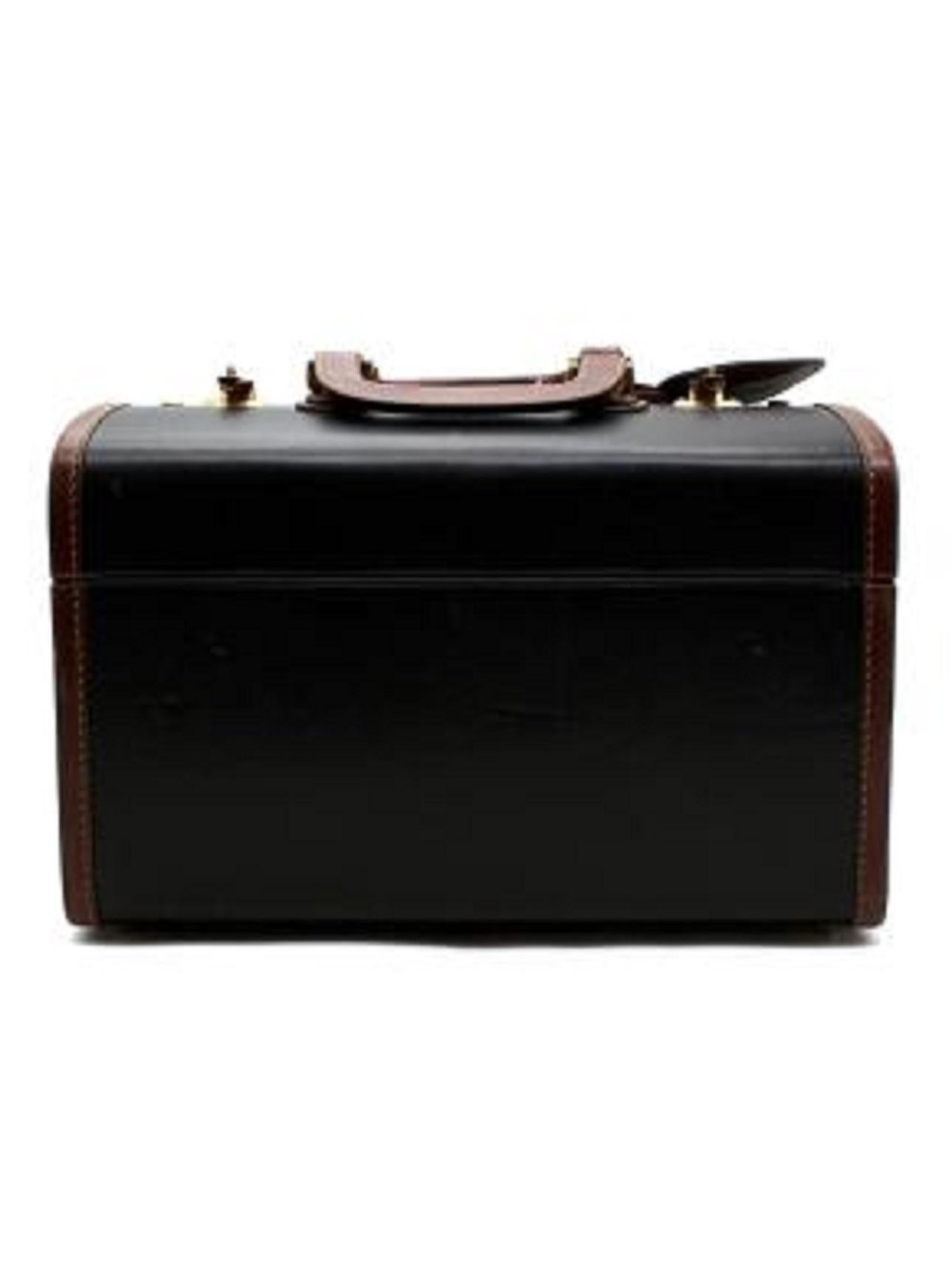 Gucci Vintage Black & Tan Leather Travel Box with Locks

- Structured leather box/case with top handles 
- Monogram canvas lining 
- 2 gold metal code locks on the top
- Double sided fold opening 
- Leather straps inside and internal pockets 
-