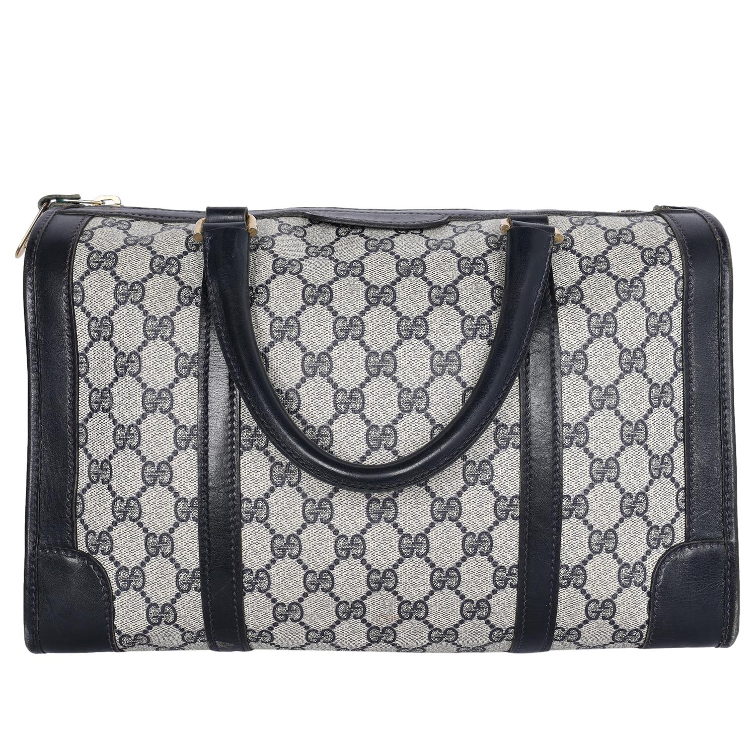 Authentic, pre-loved Gucci GG monogram blue canvas luggage top handle travel bag. Features navy blue GG monogram canvas, zipper top closure, top handles, gold hardware, large interior with zipper pocket. 

FAA approved for carrying on for all