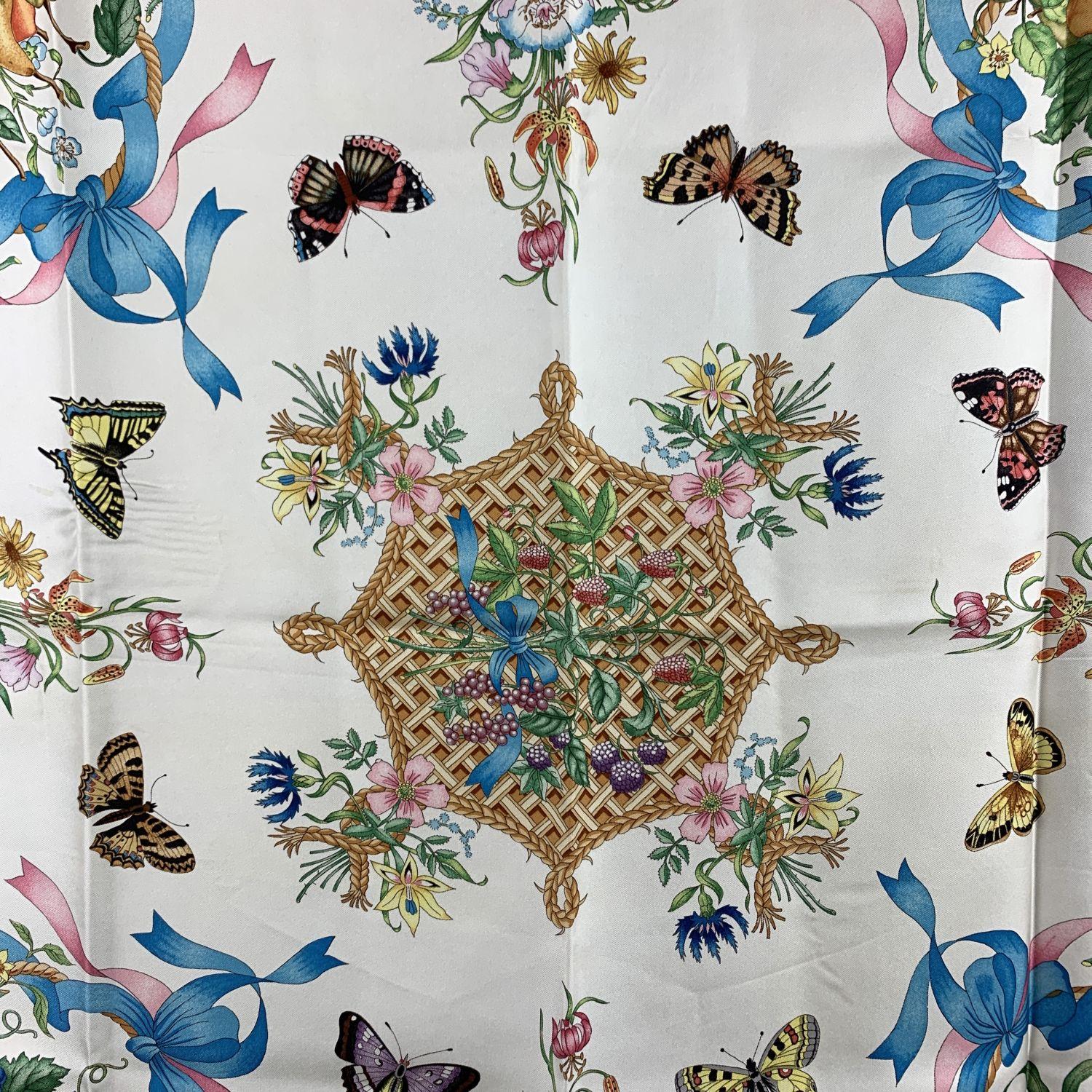 Gucci vintage silk scarf design by Vittorio Accornero in the 70s. Multicolor, baskets and fruits and ribbons and butterflies design on white background. Blue borders. 100% Silk - Printed GUCCI signature, 'V.Accornero' signature printed on the scarf.