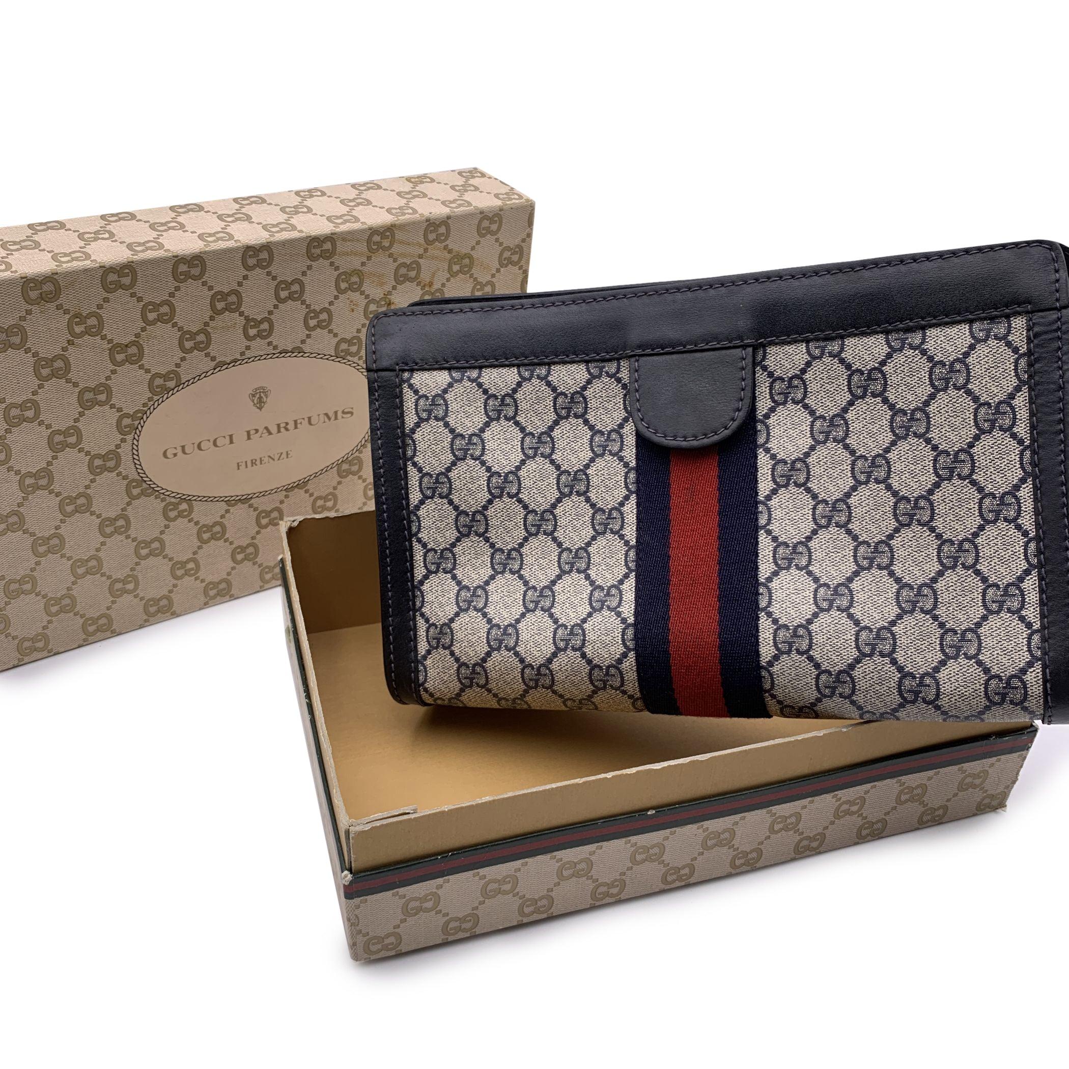 Gucci Vintage Blue Monogram Canvas Cosmetic Bag Clutch with Stripes. Blue Monogram Canvas with Genuine Leather trim. Blue/Red/blue stripes around the bag. Upper hook and loop closure. Blue lining. 'GUCCI Accessory Collection- made in Italy' tag