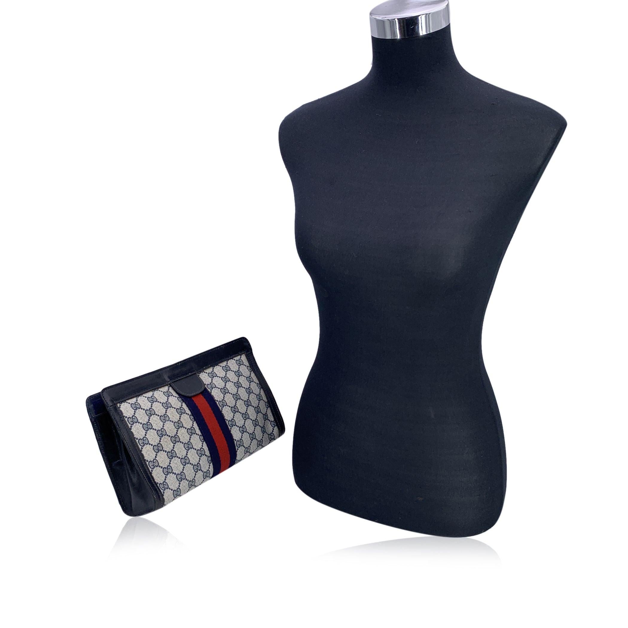 Gucci Vintage Blue Monogram Canvas Cosmetic Bag Clutch with Stripes. Blue Monogram Canvas with Genuine Leather trim. Blue/Red/blue stripes around the bag. Upper hook and loop closure. Blue lining. 'GUCCI Accessory Collection- made in Italy' tag