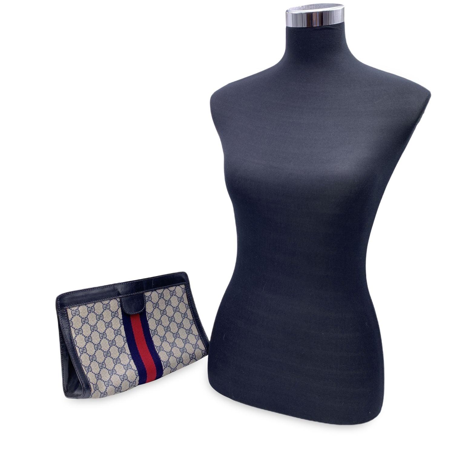 Gucci Vintage Blue Monogram Canvas Cosmetic Bag Clutch with Stripes. Blue Monogram Canvas with Genuine Leather trim. Blue/Red/blue stripes around the bag. Upper hook and loop closure. Blue lining. 'GUCCI Accessory Collection- made in Italy' tag