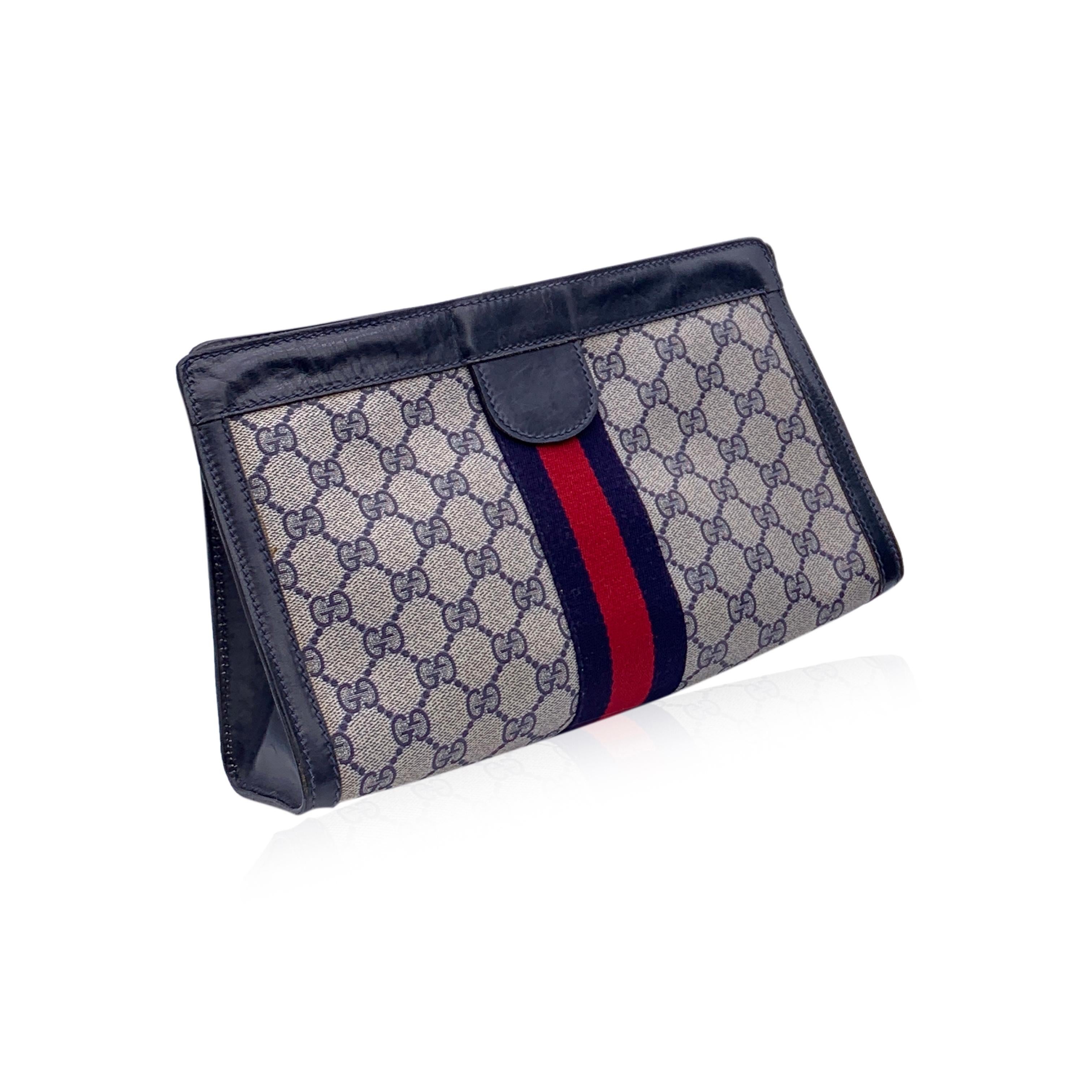 Gucci Vintage Blue Monogram Canvas Cosmetic Bag Clutch with Stripe. Blue Monogram Canvas with Genuine Leather trim. Blue/Red/blue stripes around the bag. Upper hook and loop closure. Waterproof lining. 