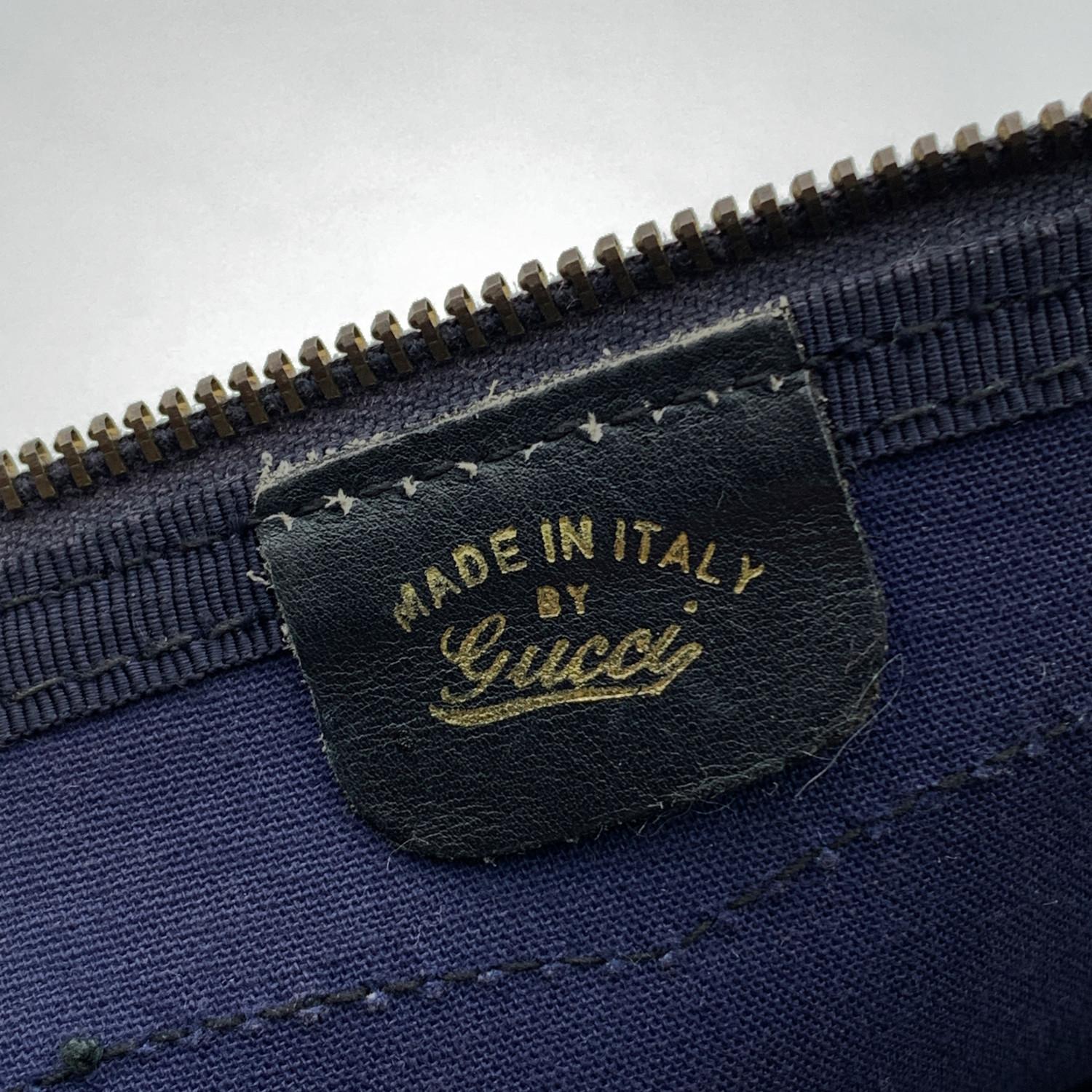 Gucci monogram canvas duffel bag. Blue GG -GUCCI monogram canvas with genuine leather trim and handles.. Blue/Red/Blue striped detailing. Upper zipper closure with side key closure (key is included). Blue fabric lining. 'Made in Italy by Gucci' tag
