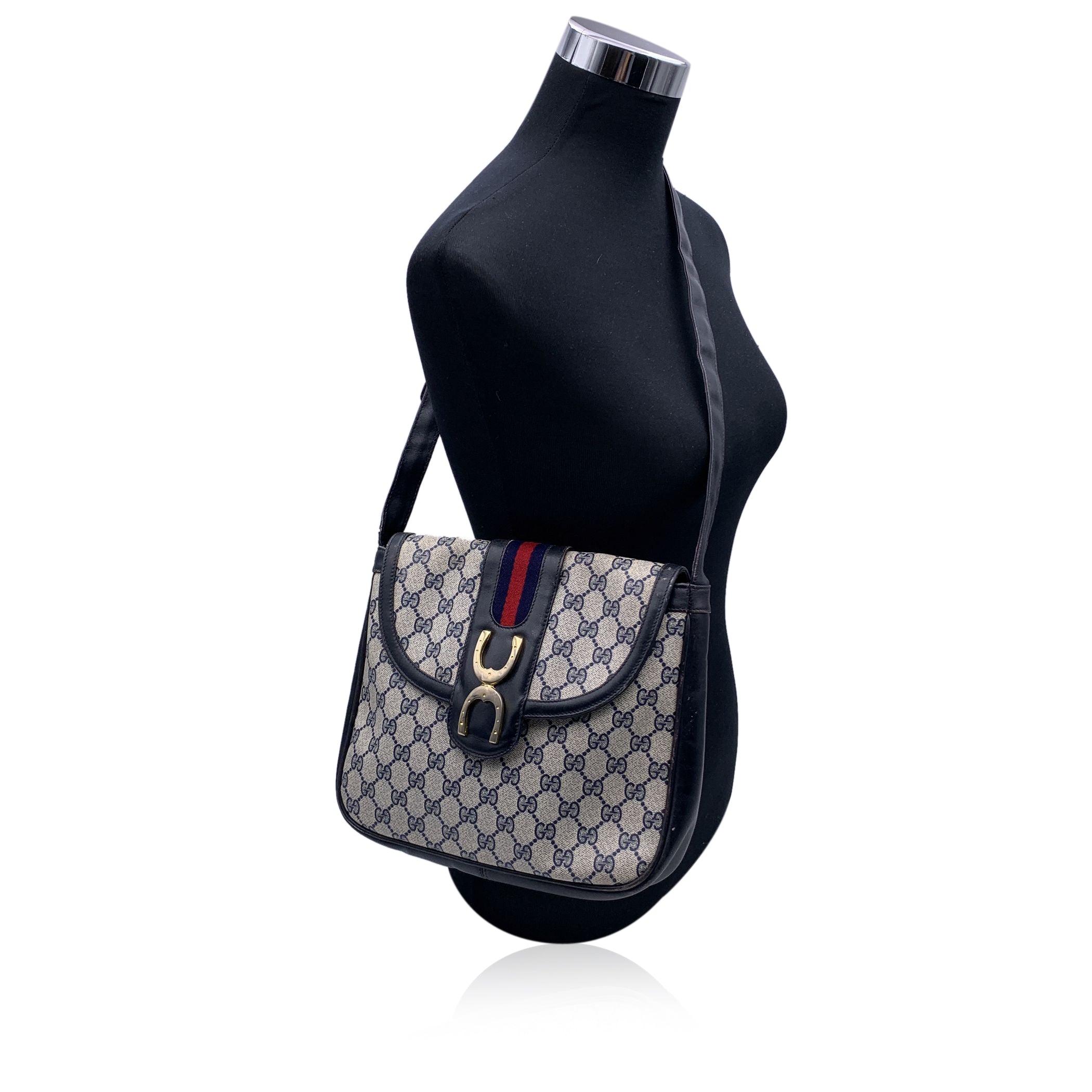 Vintage Gucci Monogram Shoulder bag. Blue monogram canvas with Genuine leather trim and leather shoulder strap. Double horseshoes detailing on the front. Flap with button closure. Blue lining, 1 side zip pocket inside. Adjustable shoulder strap.