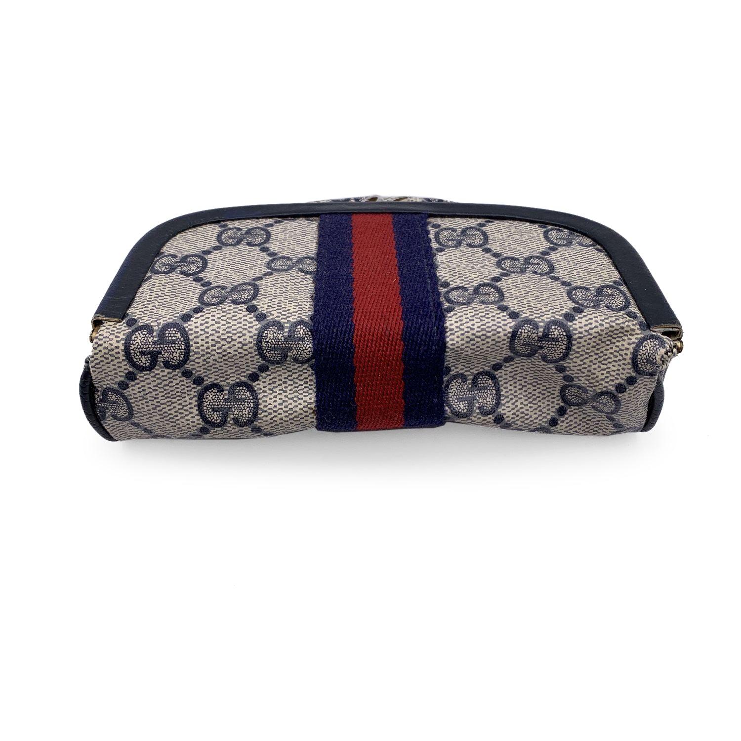 Vintage Gucci blue monogram canvas cosmetic case with stripes. Blue monogram canvas with genuine leather trim. Mirror inside. Blue/Red/blue stripes around the bag. Kiss lock closure. Blue waterproof lining. 'GUCCI Accessory collection - made in