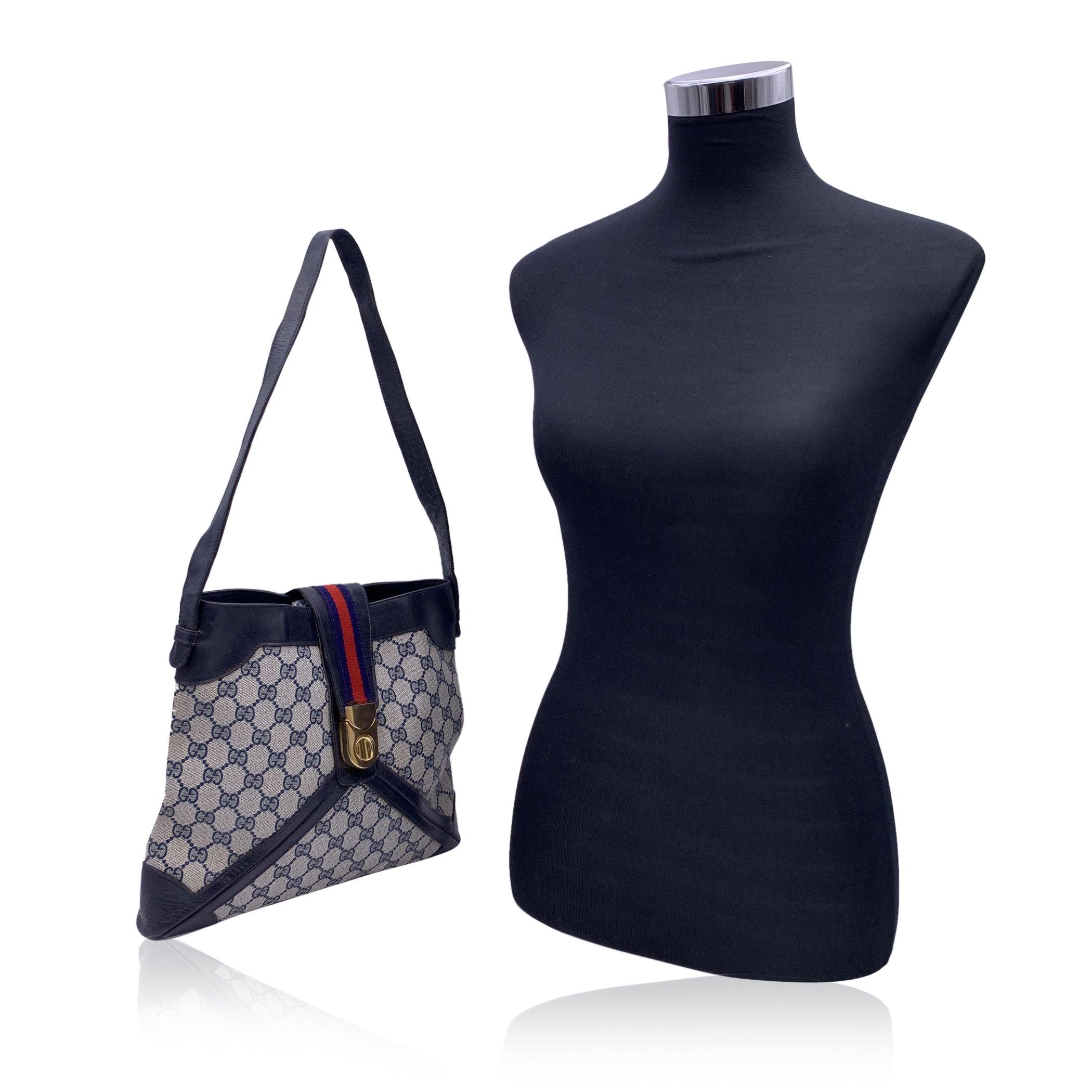 Vintage Gucci Monogram Shoulder bag. Blue monogram canvas with Genuine leather trim and leather shoulder strap. Fold over strap with twist closure. Blue fabric diamond lining, 1 side zip pocket inside. 'Made in Italy by GUCCI - Brevettato' embossed