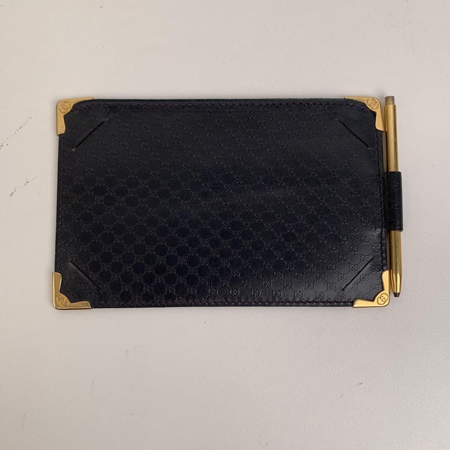 Vintage GUCCI Document Holder or wallet with gold metal mechanical pen. It is crafted in navy blue leather with embossed GG monogram pattern. Gold metal corners with engraved GG logo. it features 1 main compartment for paper or money and 4 front