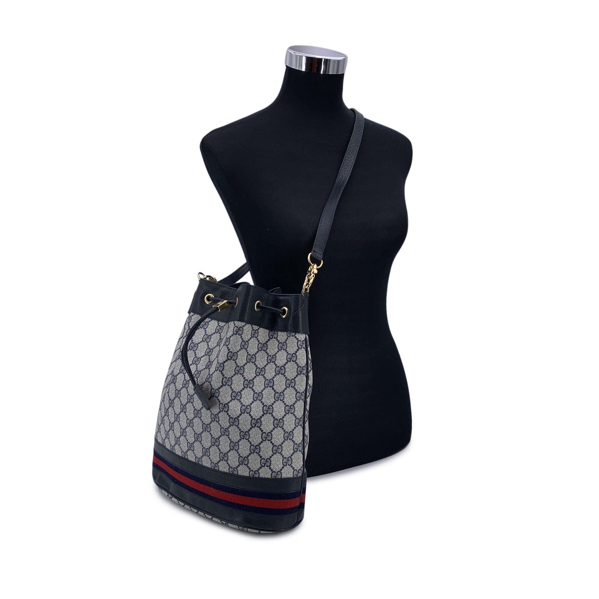 Vintage Gucci Monogram Darwstring bucket bag. Blue monogram canvas with Genuine leather trim and leather shoulder strap.Blue/red/blue stripes detailing on the bottom. FDrawstring closure. Blue lining, 1 side zip pocket inside. 'GUCCI - Made in