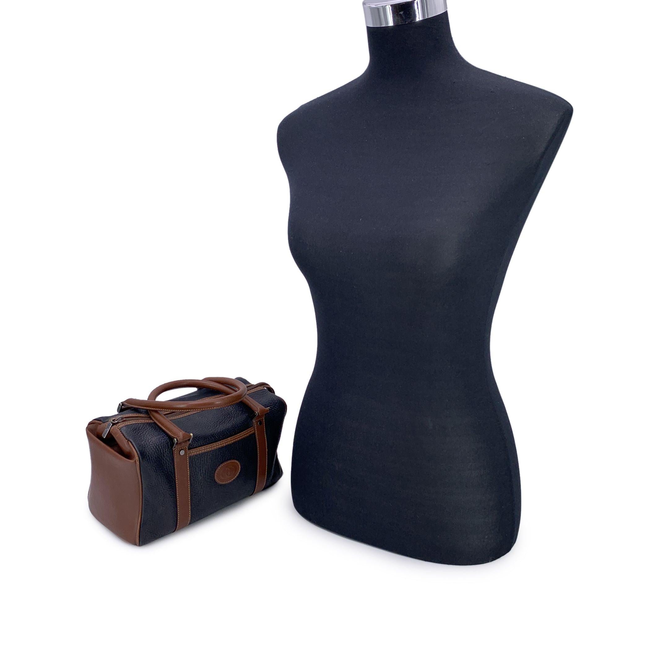 Embrace the essence of timeless luxury with this Gucci Vintage Brown and Black Leather Boston Bag, a true testament to the enduring style that the brand is renowned for. Crafted from supple brown and black leather, this bag combines both