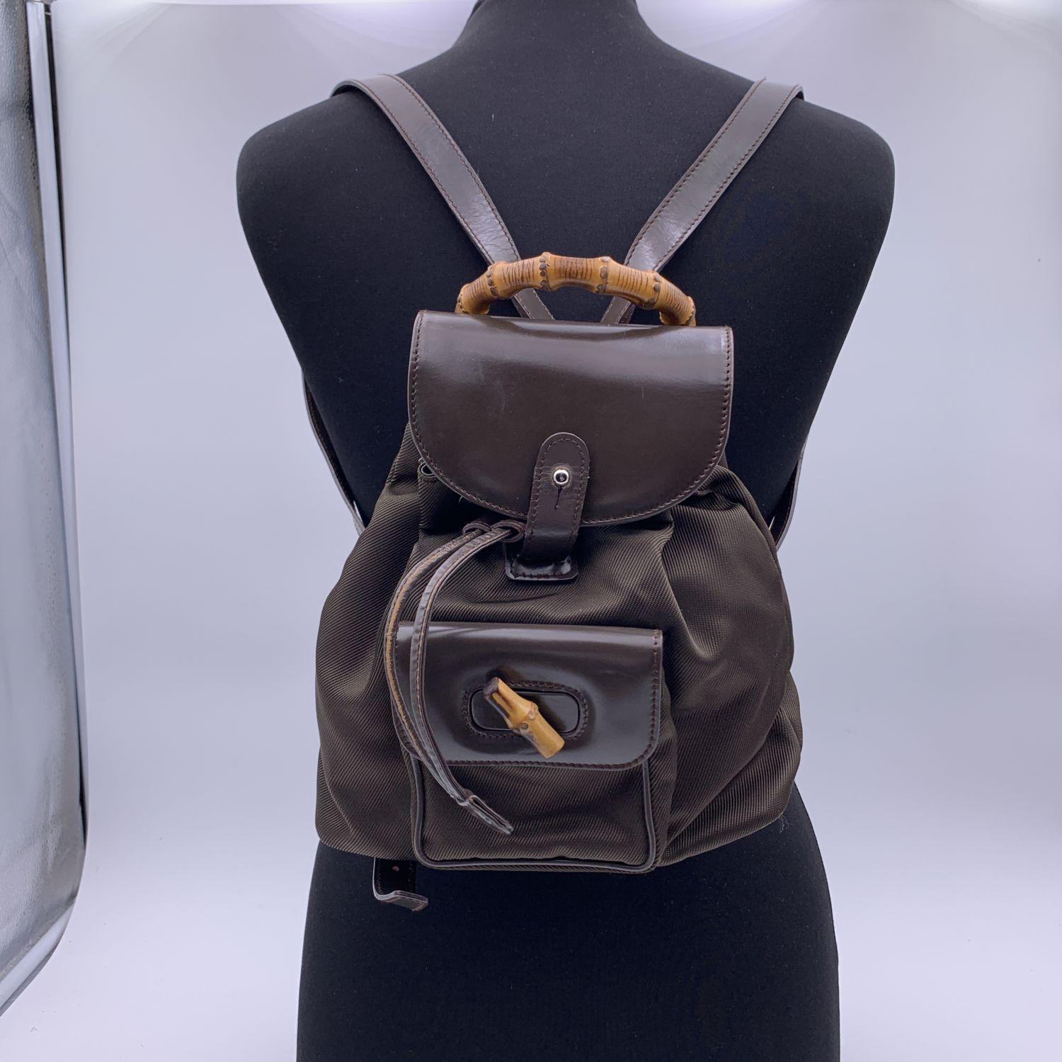 Vintage small backpack by Gucci, crafted in brown canvasand leather. It features Bamboo handle and and knob. 1 front pocket with twist lock closure. Flap closure and drawstring top opening. gold metal hardware. Internal diamond lining. 1 side zip