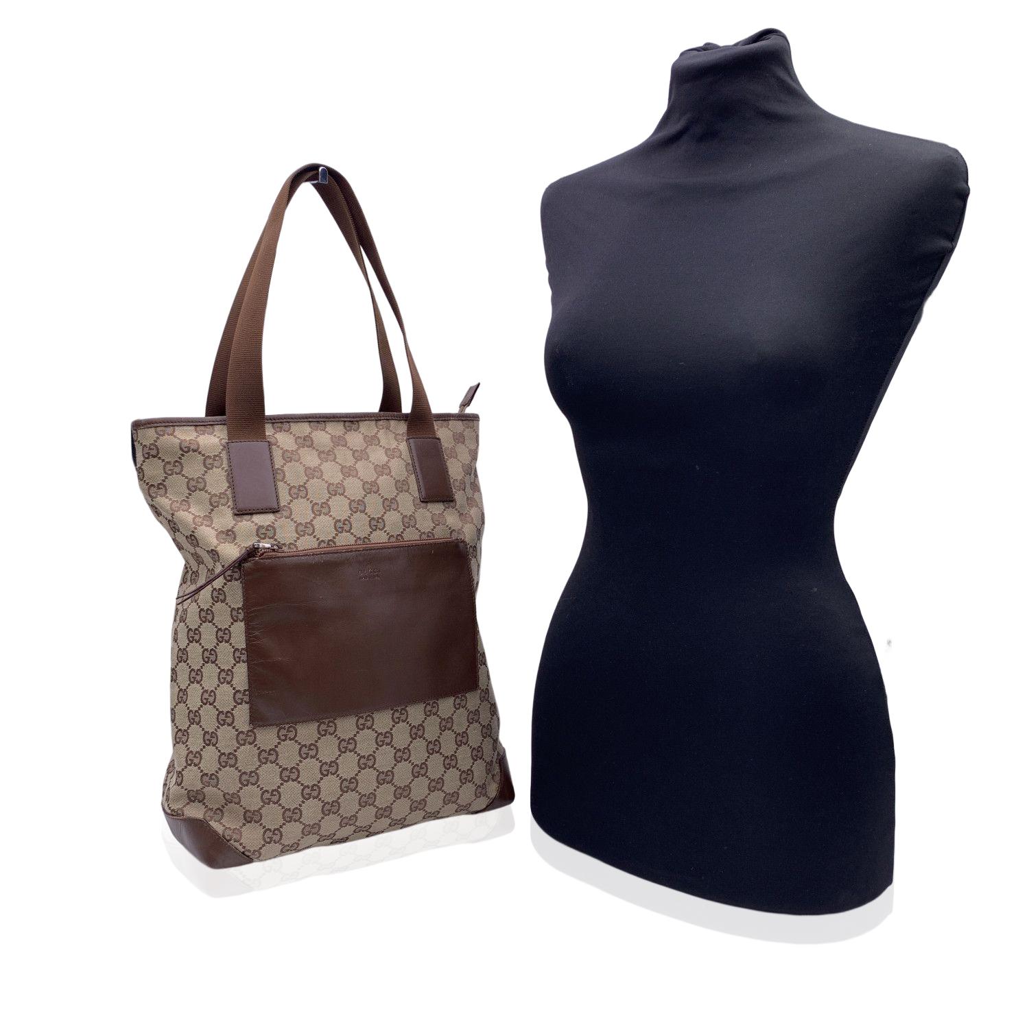 Beautiful Gucci tote made in monogram canvas with brown leather trim and front pocket. 1 front patch pocket with zip closure. Upper zipper closure. Brown canvas lining. 1 side zip pocket inside. 'GUCCI - Made in Italy' tag inside (with serial number
