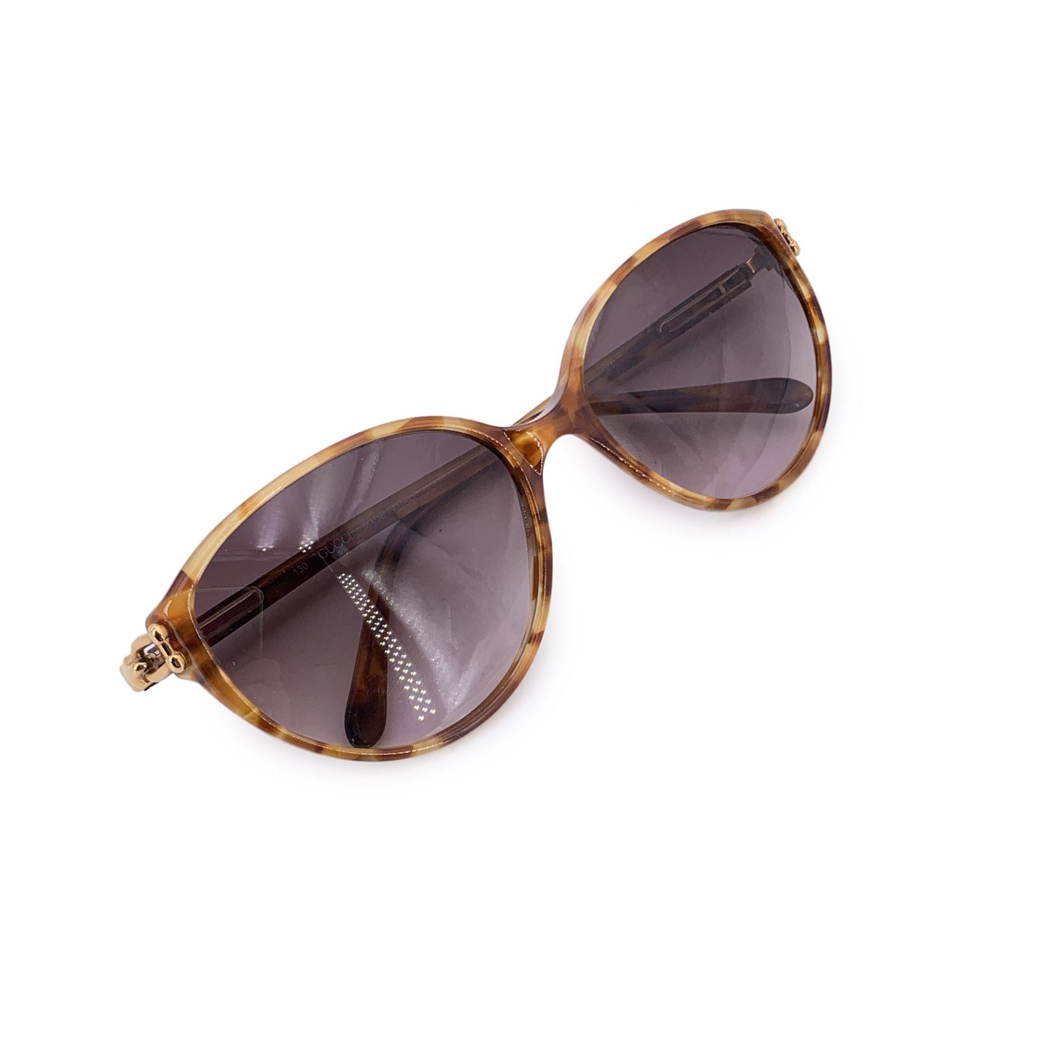 Abraza el encanto del diseño italiano vintage con estas exquisitas gafas de sol Gucci GG 2198, fiel reflejo del glamour de los años 80 y de la feminidad refinada. Con su suave silueta de ojo de gato y su rico tono marrón, ofrecen un armonioso