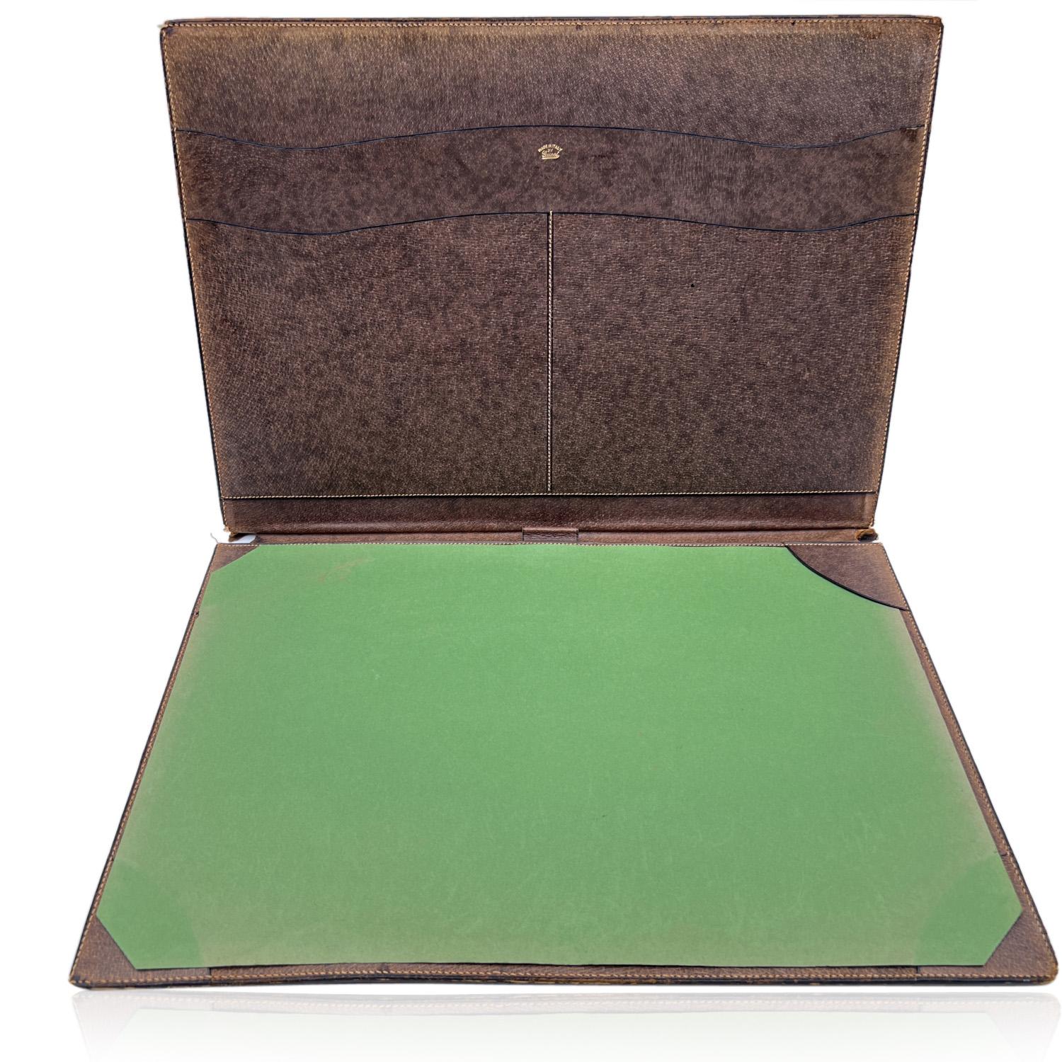Vintage desk set by GUCCI. Crafted in brown leather and gold metal. The set includes a blotter, a pen holder and a letter opener with an inset magnifying glass. Each piece is marked with Gucci signature.

MEASUREMENTS
- Blotter: 18.5 x 13.5 inches -