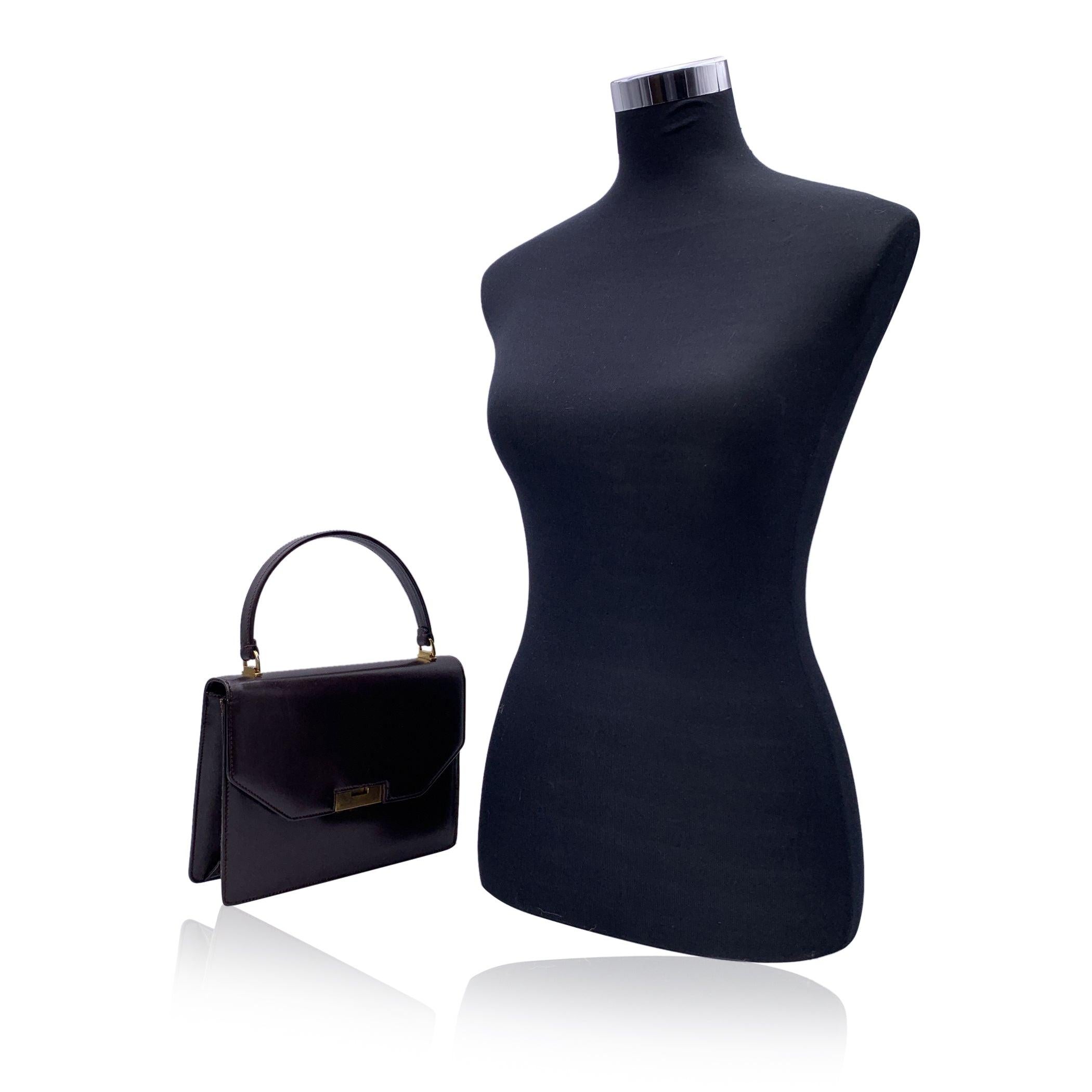Beautiful Vintage Gucci handbag made in brown leather. Gold metal closure on the front. Top carry handle. Brown leather interior. 1 side open pocket inside. 'Made in Italy by Gucci' embossed inside. Condition C - FAIR Some scratches on leather due
