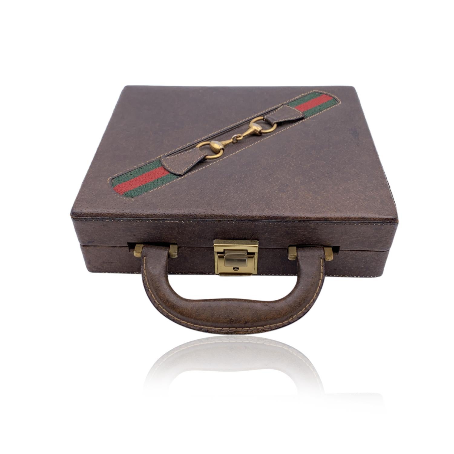 Rare travel poker set was made by Gucci, from the 70s. The travel case is made from dark pigskin leather and features Gucci's iconic green/red/green striping with a gold metal horsebit. The case is lined in green felt and it has one divider tray.