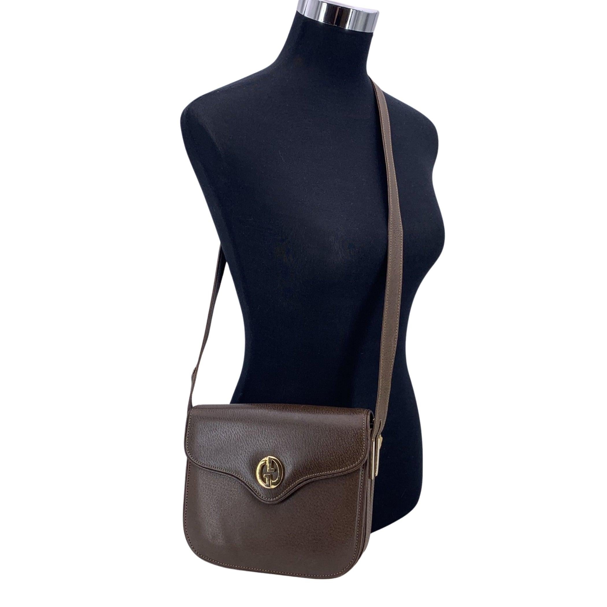 Incarnation intemporelle de l'élégance discrète, ce sac à bandoulière vintage Gucci est réalisé en cuir marron, conçu pour celles qui apprécient la grâce sans effort du style italien classique. La silhouette structurée est dotée d'une élégante