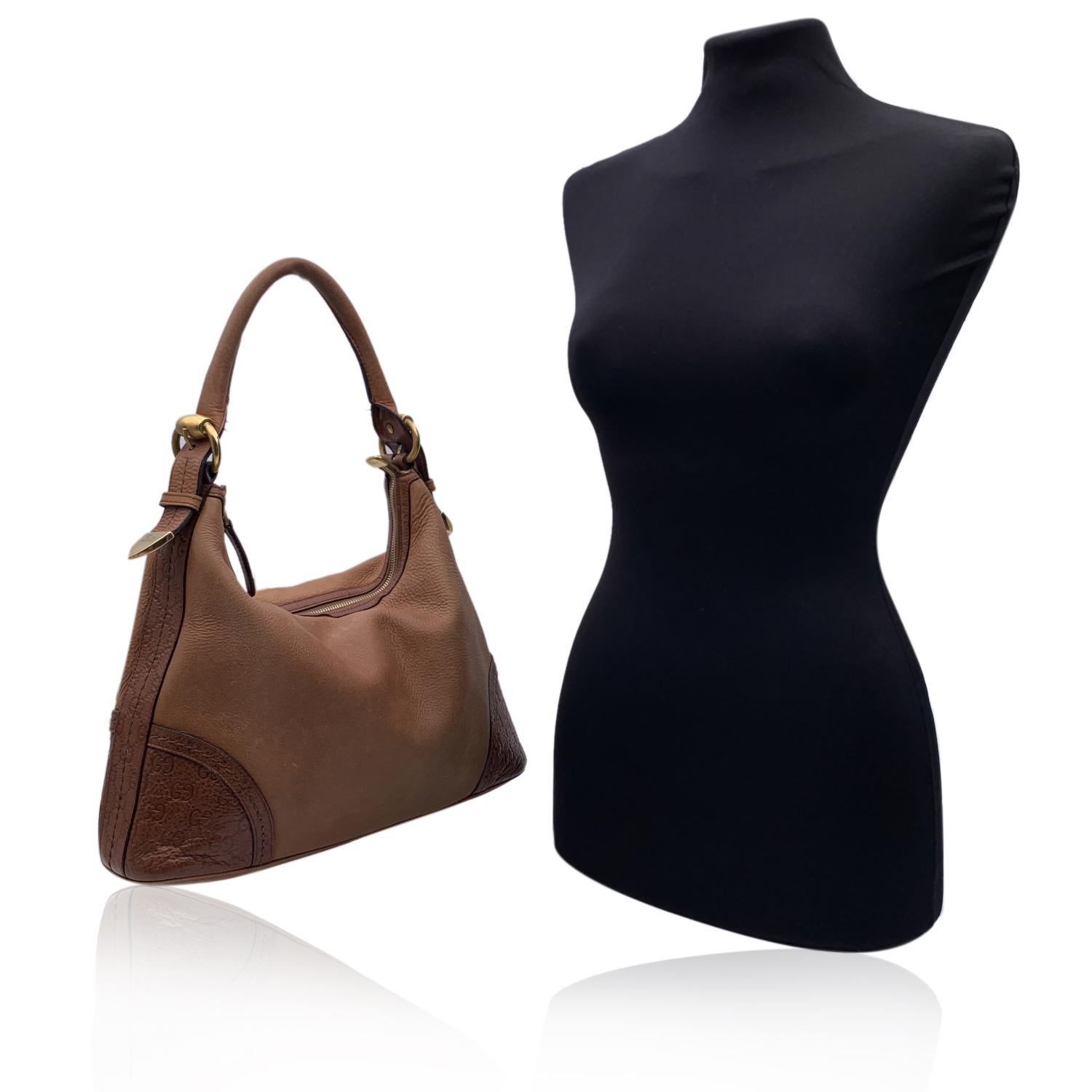 Beautiful Gucci hobo bag, crafted in light brown leather. Horsebit pattern engraved on leather patch on the corners. Upper zipper closure. Canvas interior with 1 side zip pocket inside. 'Gucci - made in italy' tag inside (with serial number on its