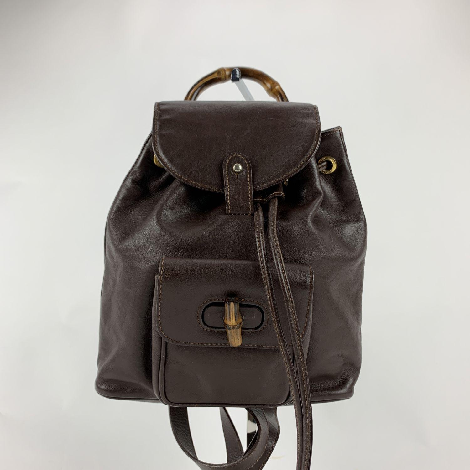 Vintage small backpack by Gucci, crafted in brown leather. It features Bamboo handle and and knob. 1 front pocket with twist lock closure. Flap closure and drawstring top opening. gold metal hardware. Internal diamond lining. 1 side zip pocket