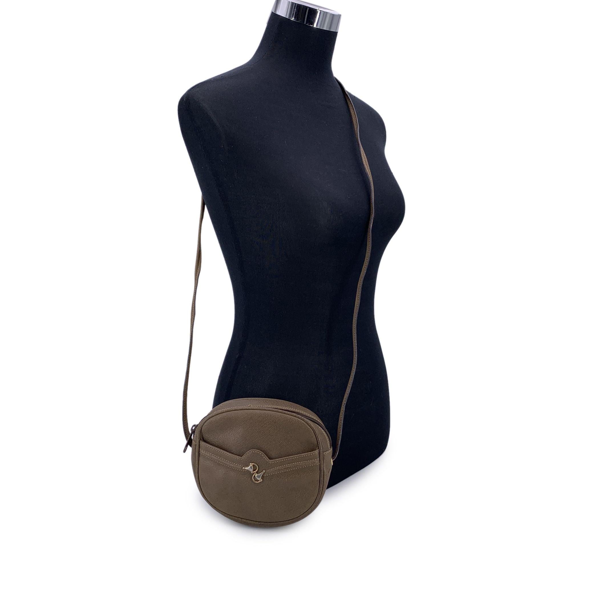 Charmant par sa taille et son style, ce magnifique sac à bandoulière vintage Gucci est réalisé en cuir marron riche, offrant un look intemporel avec une touche équestre raffinée. La silhouette compacte est rehaussée d'une poche ouverte sur le devant