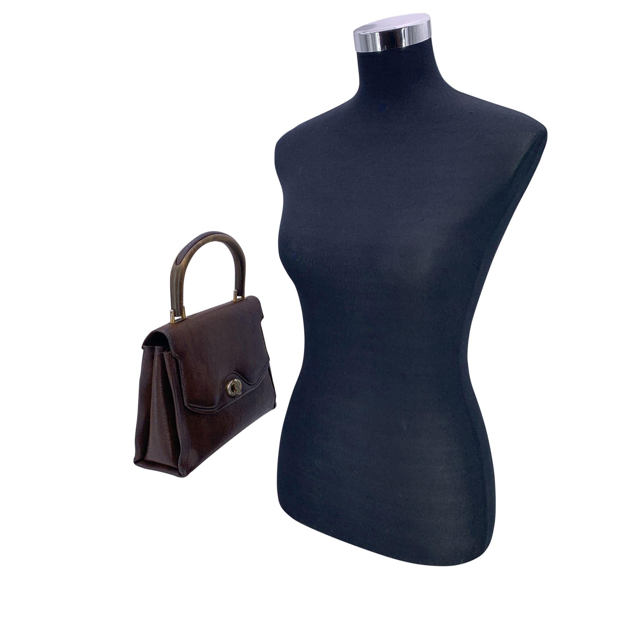 Diese Gucci-Handtasche aus braunem Leder ist ein bemerkenswertes Stück italienischer Handwerkskunst im Vintage-Stil. Sie ist ein seltener Fund, der Eleganz aus der alten Welt mit einem Hauch von irdischem Charme ausstrahlt. Das herausragende Merkmal