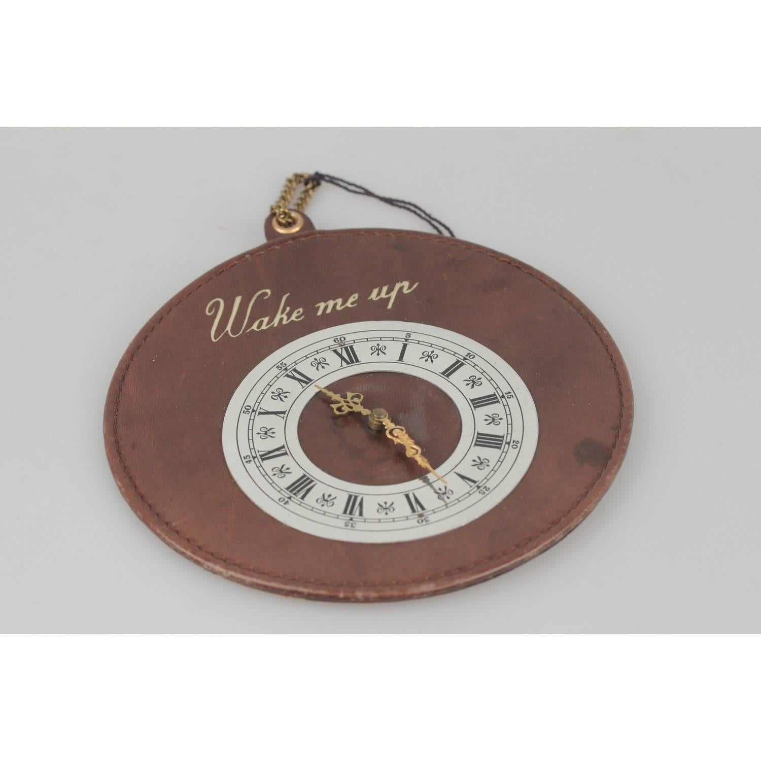- Rare GUCCI vintage waking up door sign 
- Brown leather disk with mock clock
- 'Wake me up' writing embossed on the front
- Marked 'Made in Italy by GUCCI' on the back
- Diameter: 5.75 inches - 14,6 cm