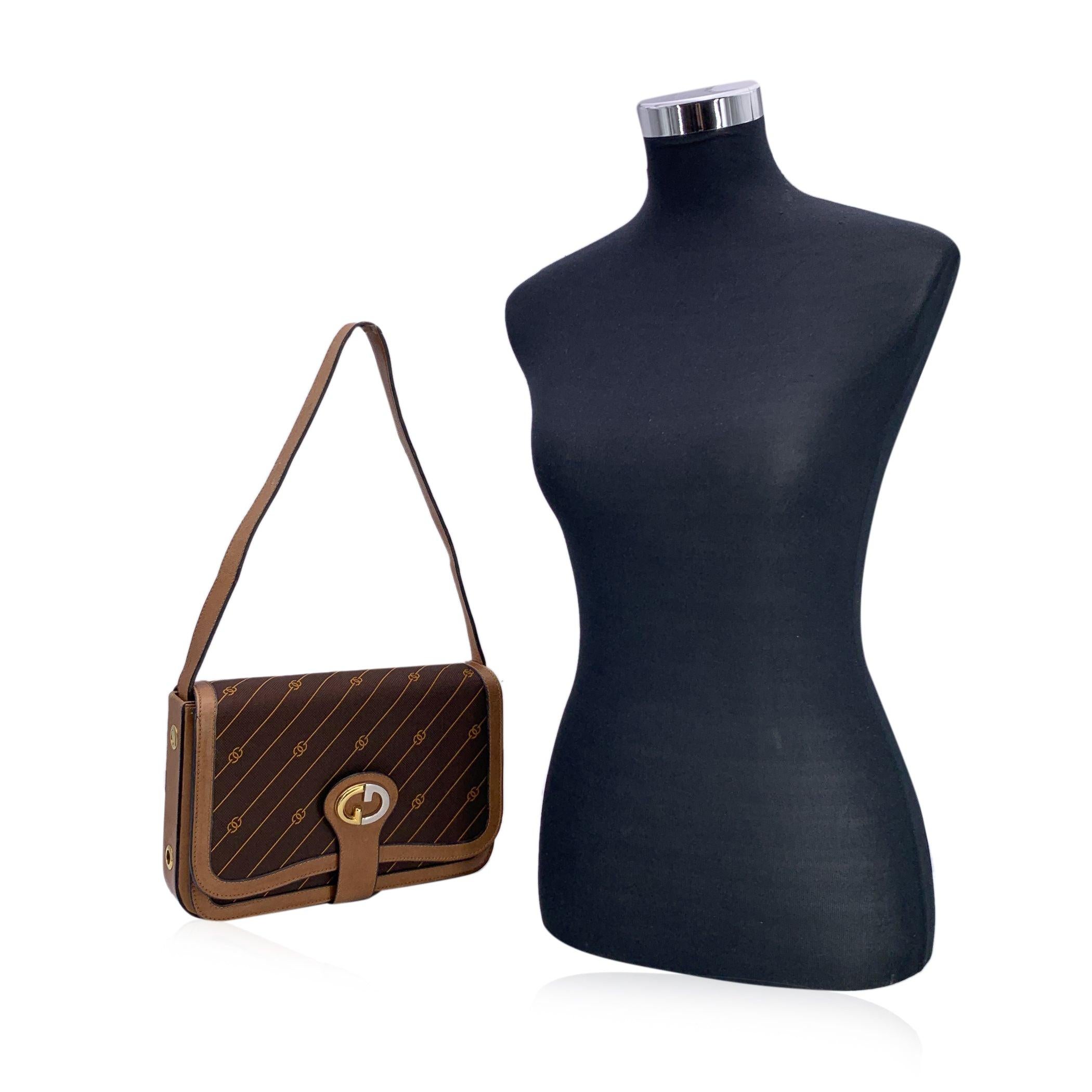 Adoptez une pièce de luxe vintage avec ce sac à bandoulière Gucci, un classique intemporel qui allie à la perfection design iconique et praticité. Confectionné en toile marron riche, orné des rayures et du logo GG emblématiques de Gucci, ce sac