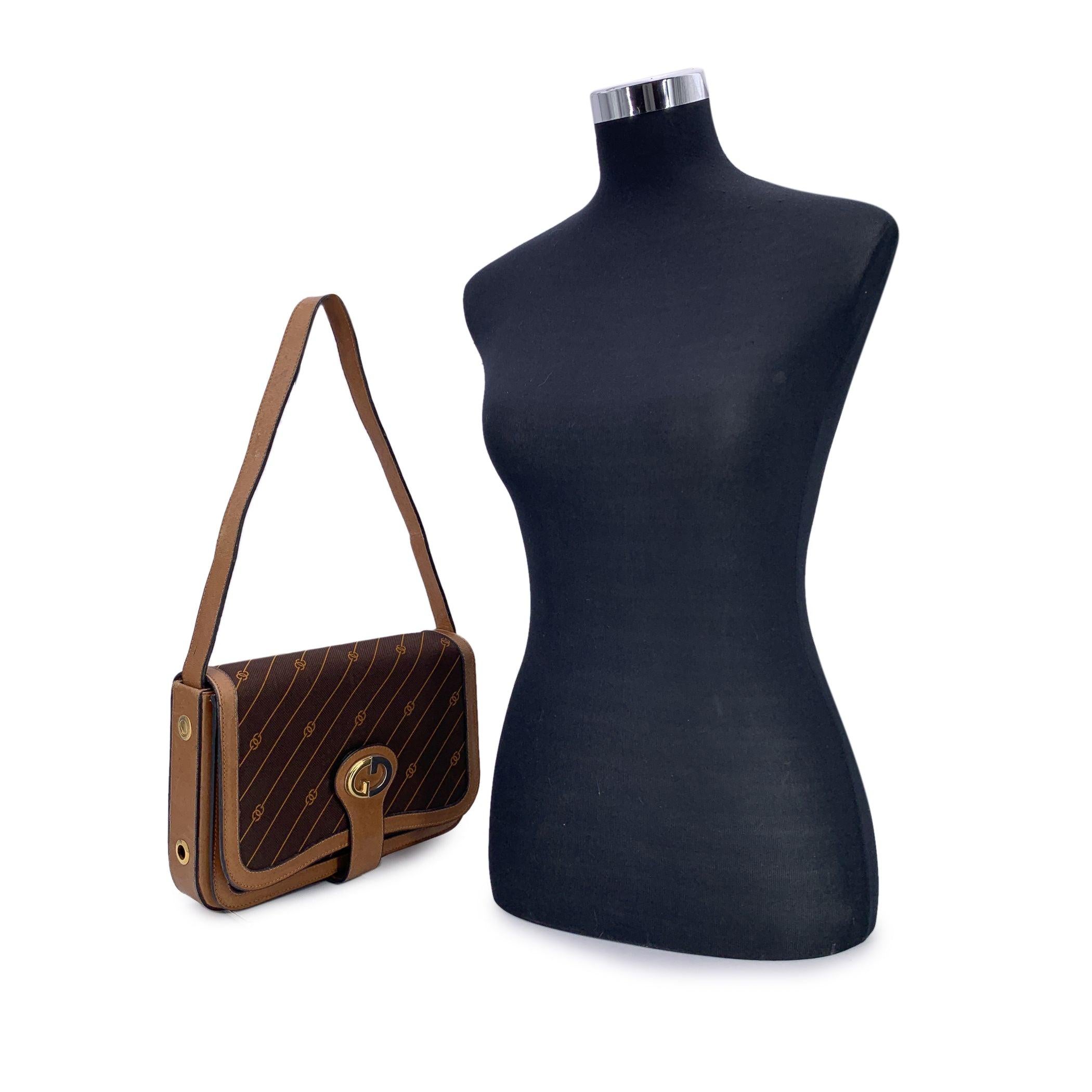 Adoptez une pièce de luxe vintage avec ce sac à bandoulière Gucci, un classique intemporel qui allie à la perfection design iconique et praticité. Confectionné en toile marron riche, orné des rayures et du logo GG emblématiques de Gucci, ce sac