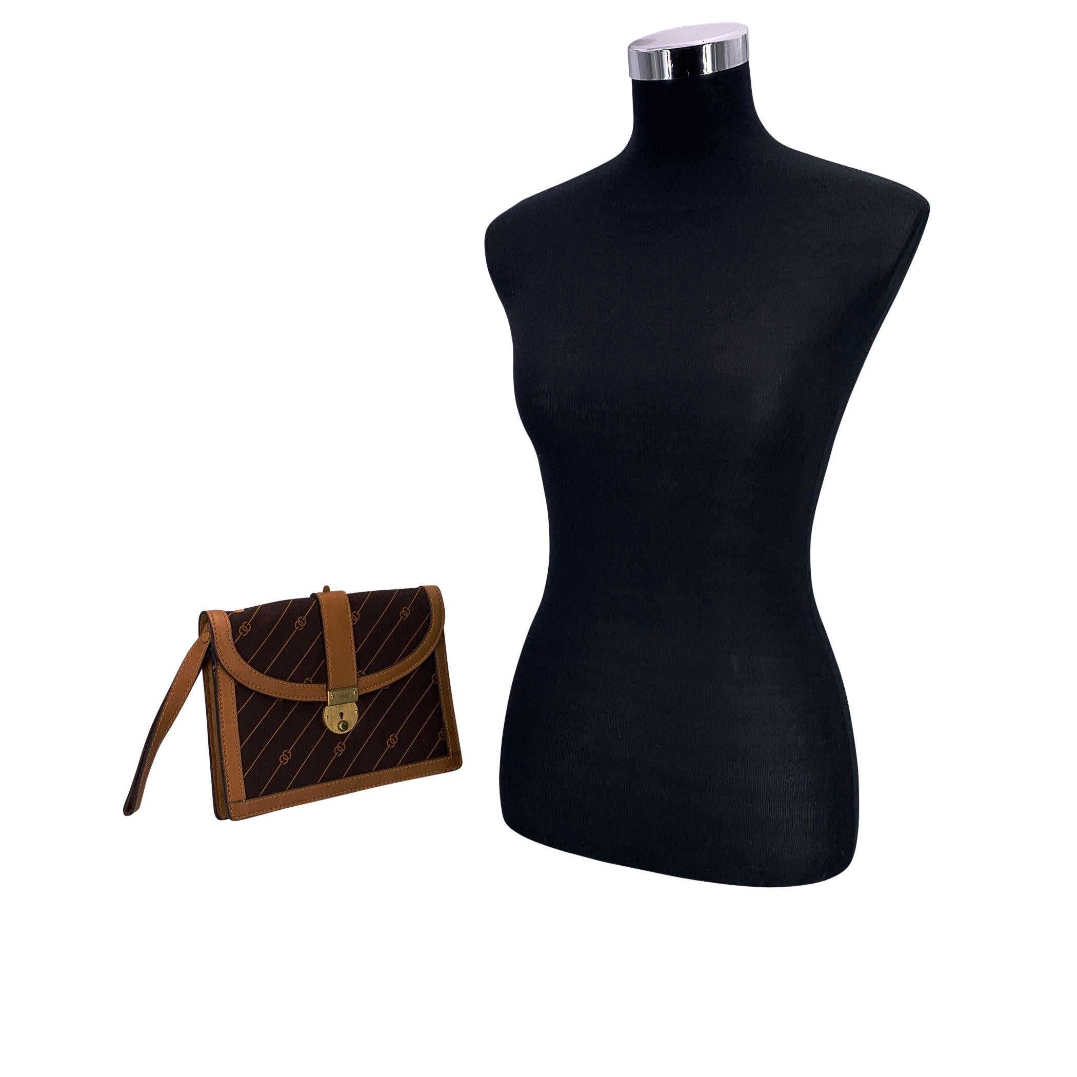 Ein zeitloses Stück Vintage-Luxus von Gucci, gefertigt aus braunem Canvas mit dem charakteristischen GG Diagonalmuster und Streifen. Hellbraune Lederakzente und goldene Beschläge sorgen für Wärme und Eleganz. Die Klappe öffnet sich zu einem gut