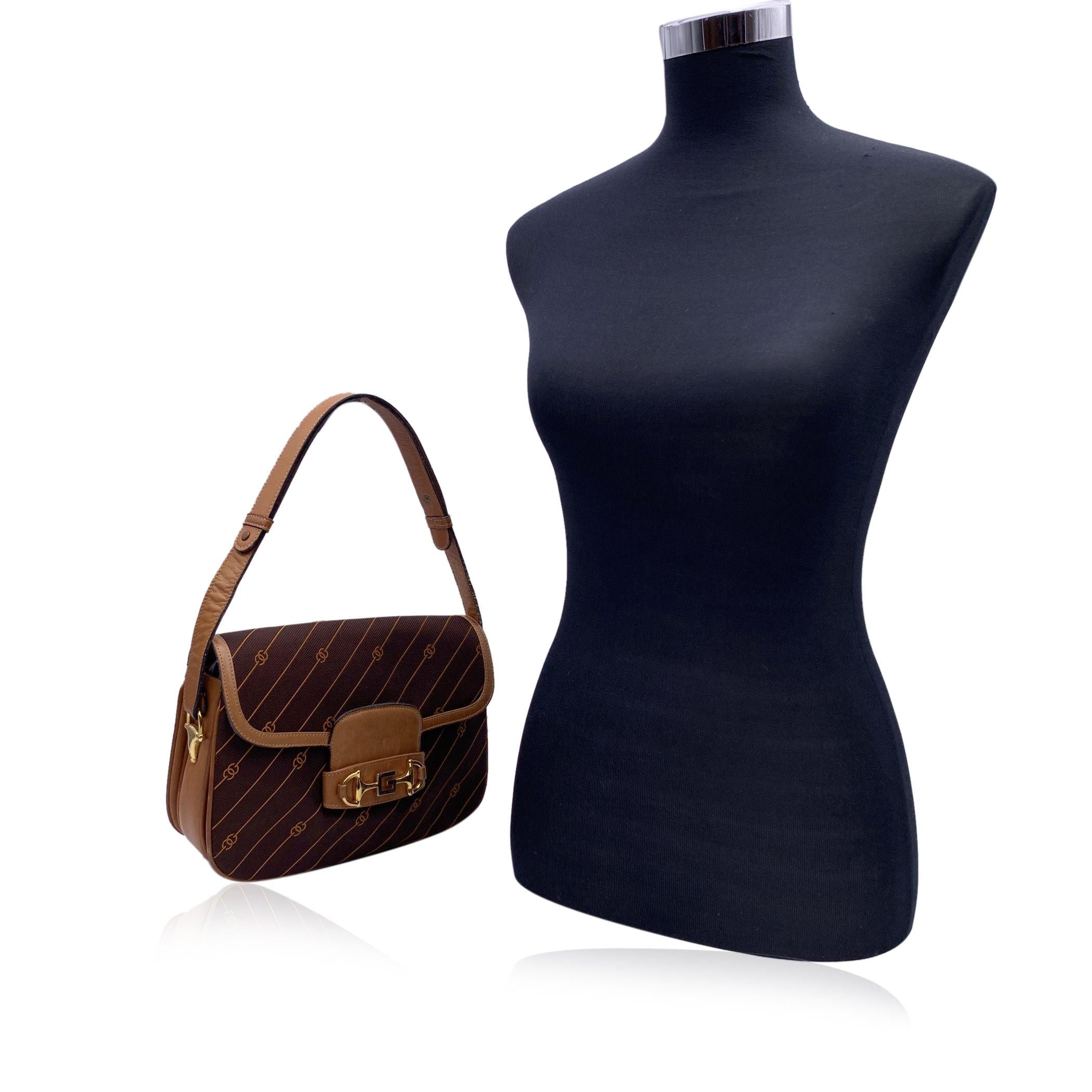 Embrace a piece of vintage luxury with this Gucci Shoulder Bag, a timeless classic that perfectly blends iconic design with practicality. Crafted in rich brown canvas adorned with Gucci's signature stripes and GG logo pattern, this bag radiates