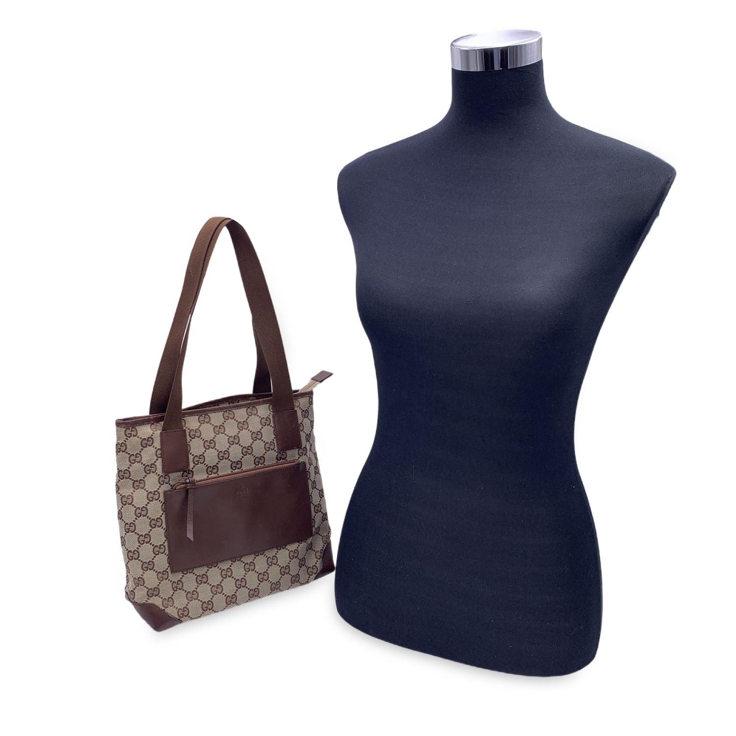 Beautiful Gucci tote made in monogram canvas with brown leather trim and front pocket. 1 front patch pocket with zip closure. Upper zipper closure. Brown canvas lining. 1 side zip pocket inside. 'GUCCI - Made in Italy' tag inside (with serial number