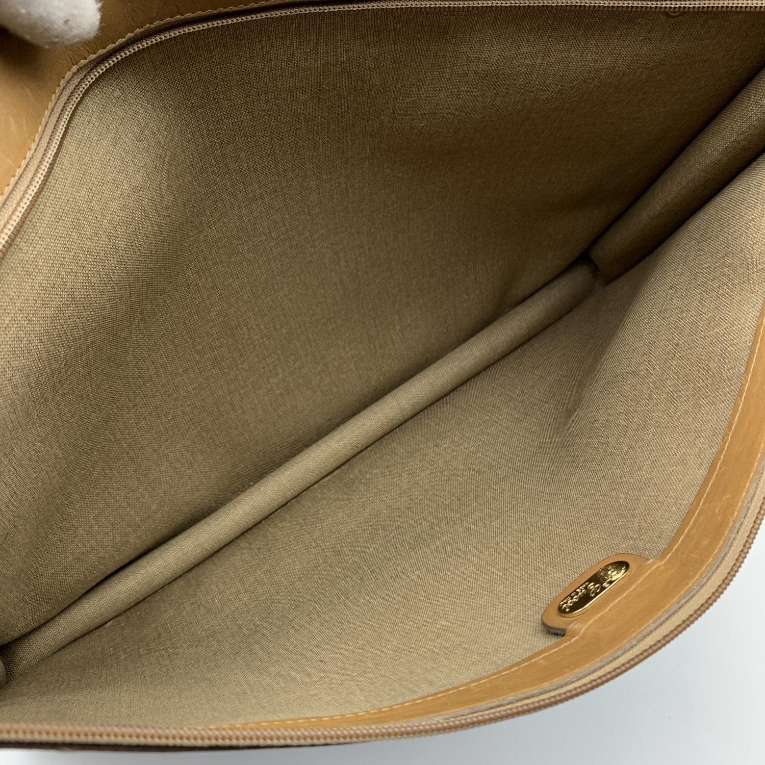Vintage Gucci brown GG monogram canvas portfolio bag with beige leather lining. It features a front zipper closure and gold meta zipper pull with engraved GG logo. The interior of the portfolio is lined in beige canvas. 'GUCCI - Made in Italy' tags